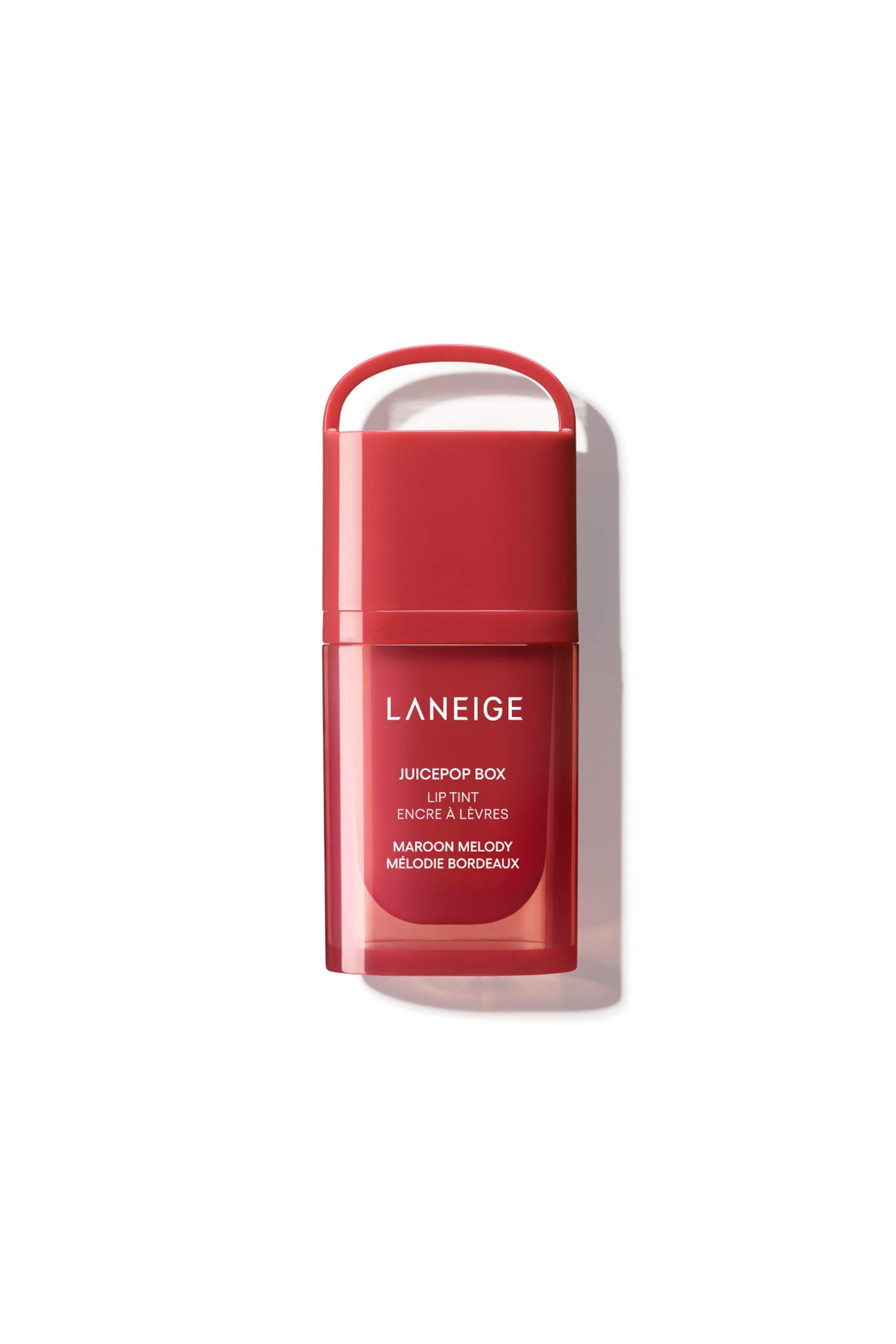 Näytä suurempi kuva: Laneige Juicypop Box Lip Tint seisoo pystyasennossa ja on suunnattu eteenpäin. Siinä on läpinäkymätön punaruskea korkki, jossa on puolipyöreä kahva, ja läpikuultava punaruskea säiliö. Säiliössä lukee valkoisella tekstillä "LANEIGE", "JUICEPOP BOX", "LIP TINT", "ENCRE À LÈVRES", "MAROON MELODY" ja "MÉLODIE BORDEAUX".