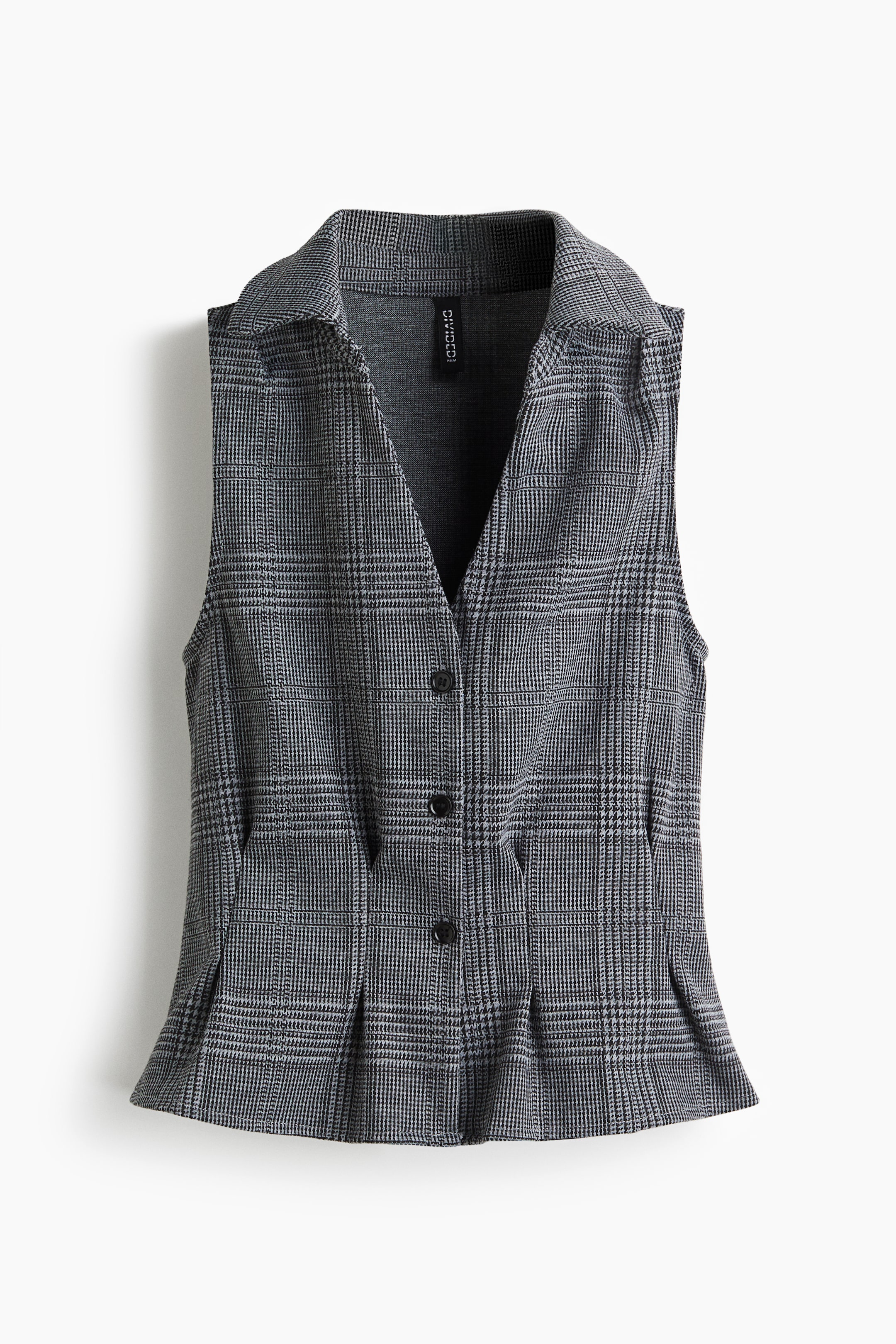 View larger image: A gray and white plaid vest is being presented from the front, featuring a V-neckline with a pointed collar. It has three visible black buttons down the front, two angled slash pockets at the waist, and a pleated peplum hem.