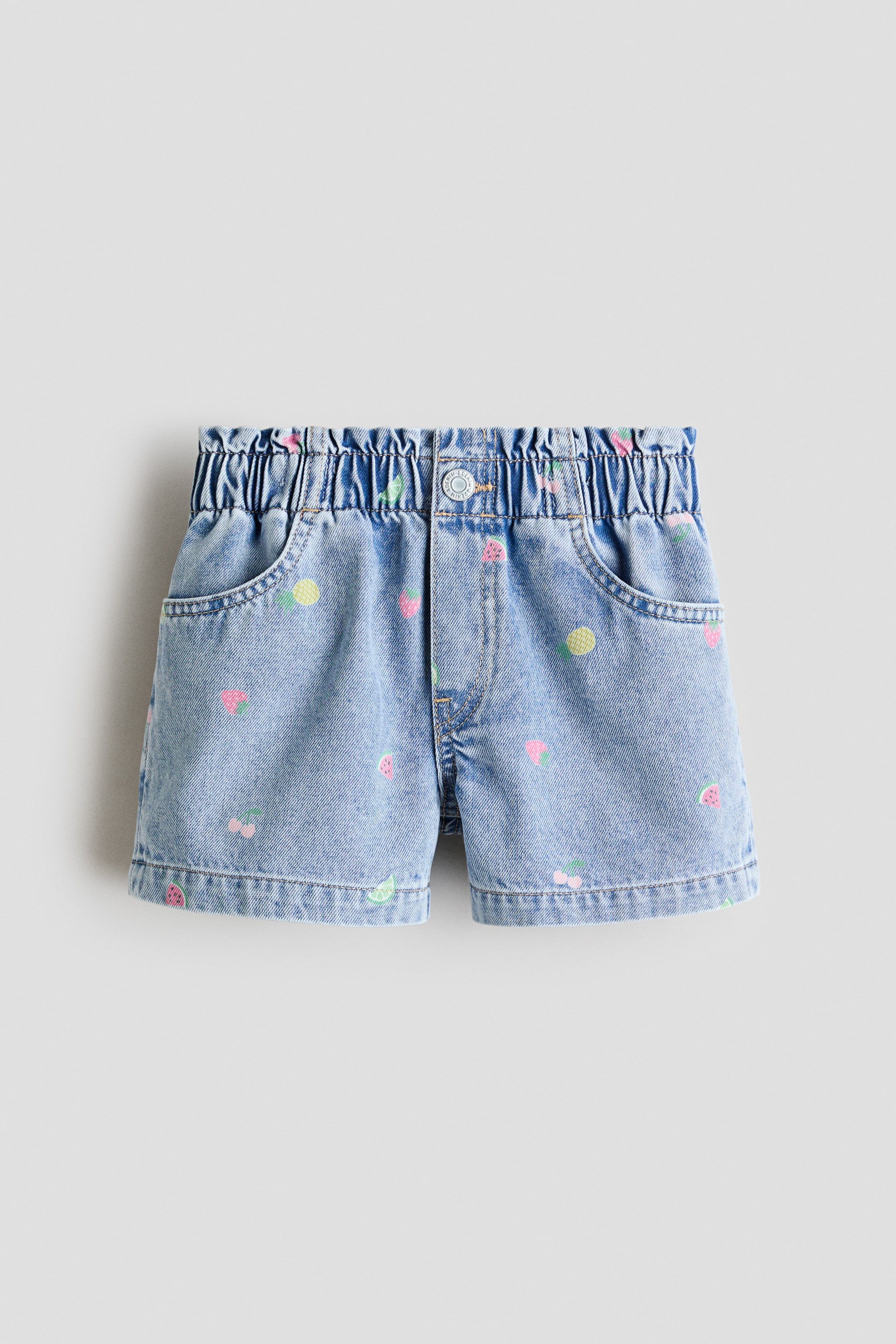 Visualizza immagine più grande: I pantaloncini in denim di cotone sono presentati in vista frontale, con una vita elasticizzata a sacchetto di carta, una patta finta e una chiusura a pressione. I pantaloncini sfoggiano un motivo di frutta ricamata e presentano due tasche frontali.