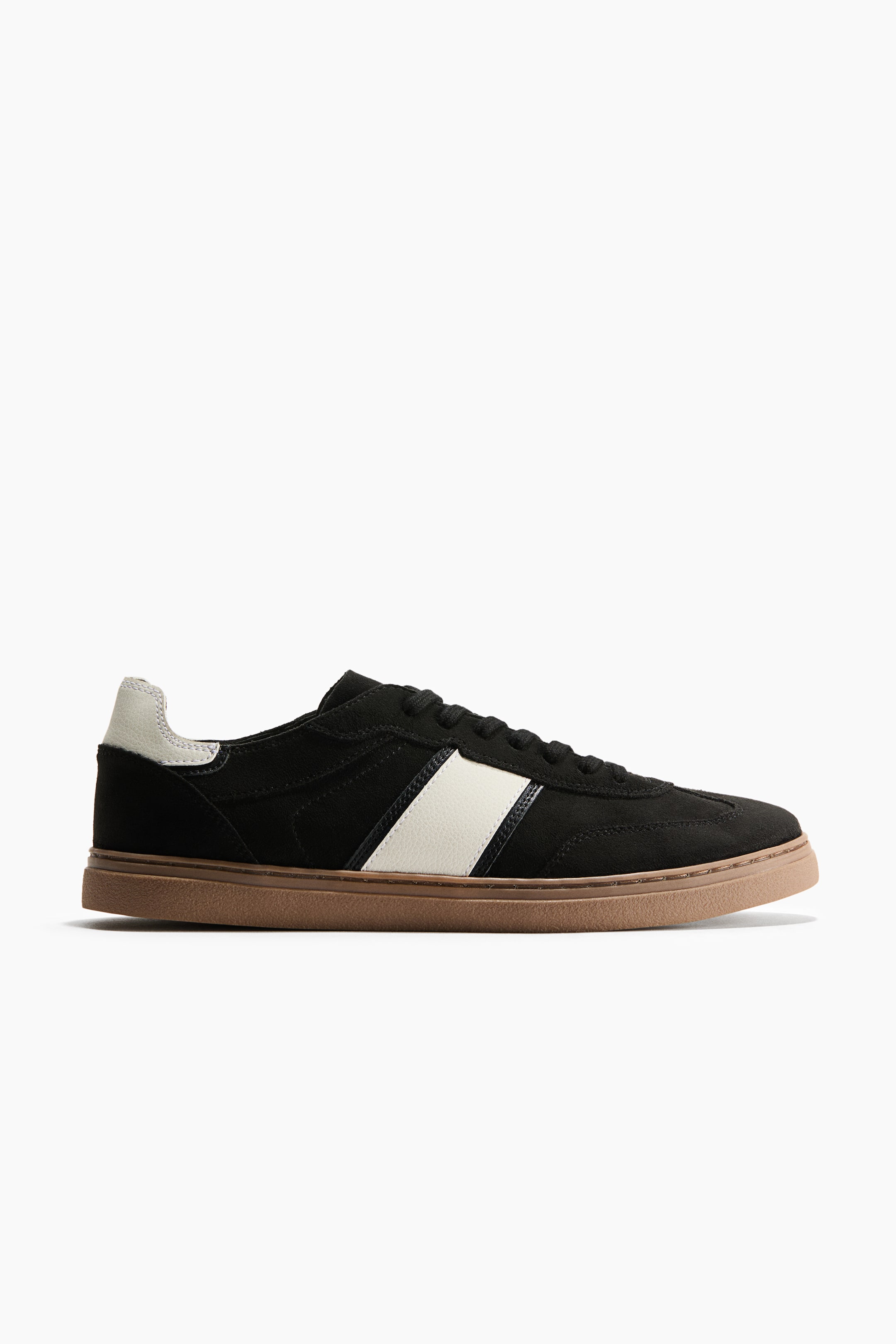 View larger image: A black low-top sneaker is facing right in side profile, featuring a black suede upper with a wide diagonal off-white stripe on the side. The sneaker is designed with matching black laces, an off-white heel tab, and a contrasting brown gum outsole.