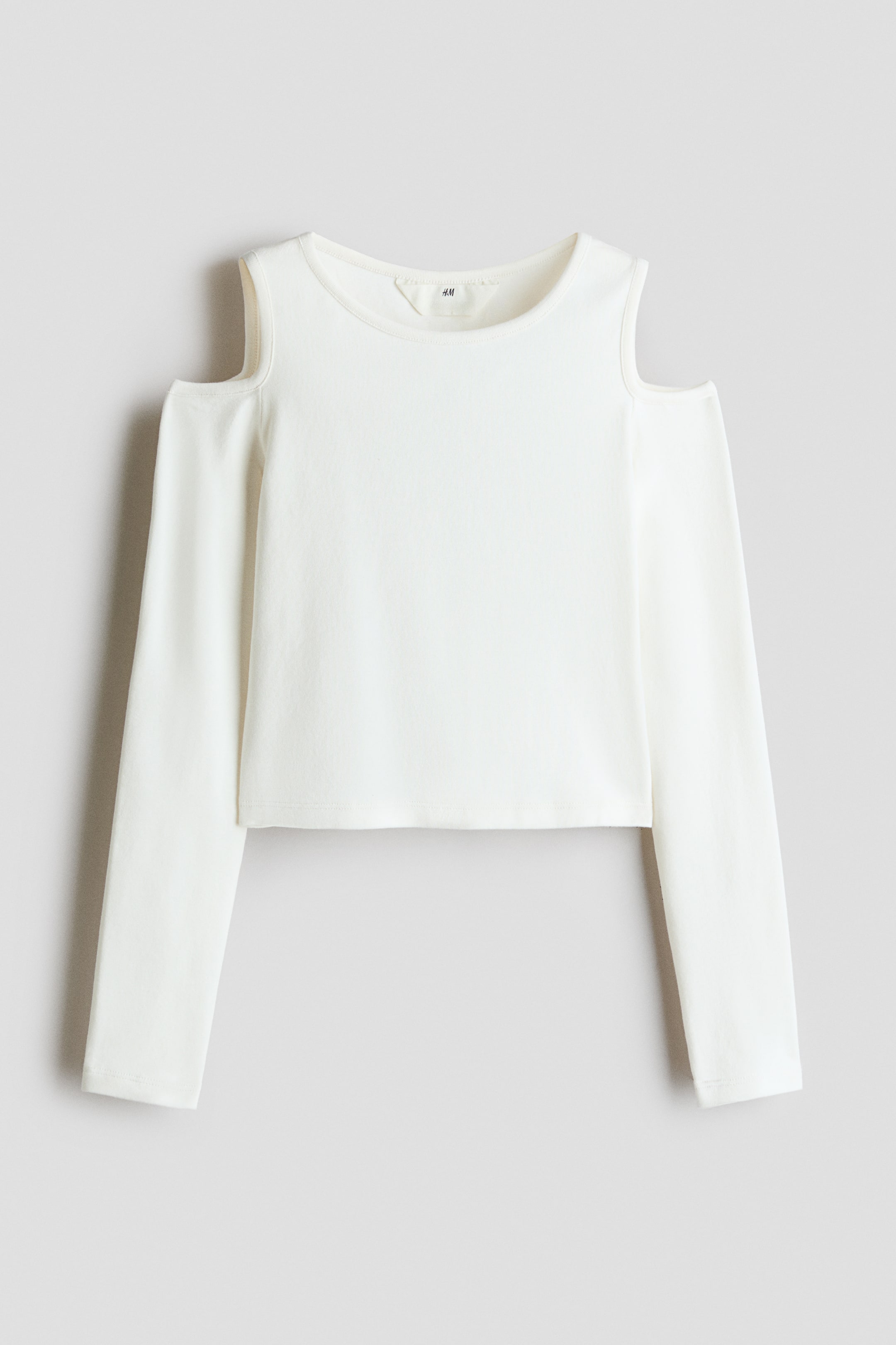 View larger image: A white ribbed-knit top featuring a round neckline, cold-shoulder cut-outs on the long sleeves, and a straight cropped hem in a front-facing view.