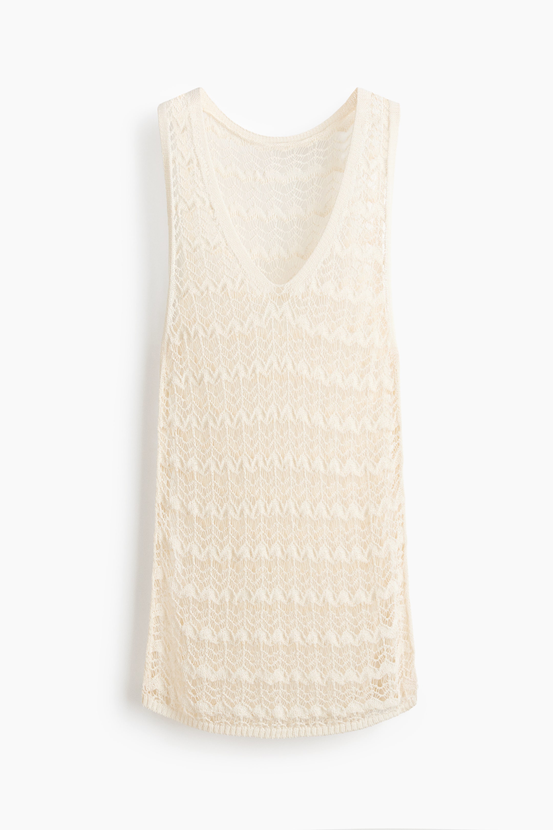 View larger image: The front view showcases a cream sleeveless top, highlighting its V-neckline and an open-knit chevron pattern throughout the body, complemented by a tightly knit bottom hem.