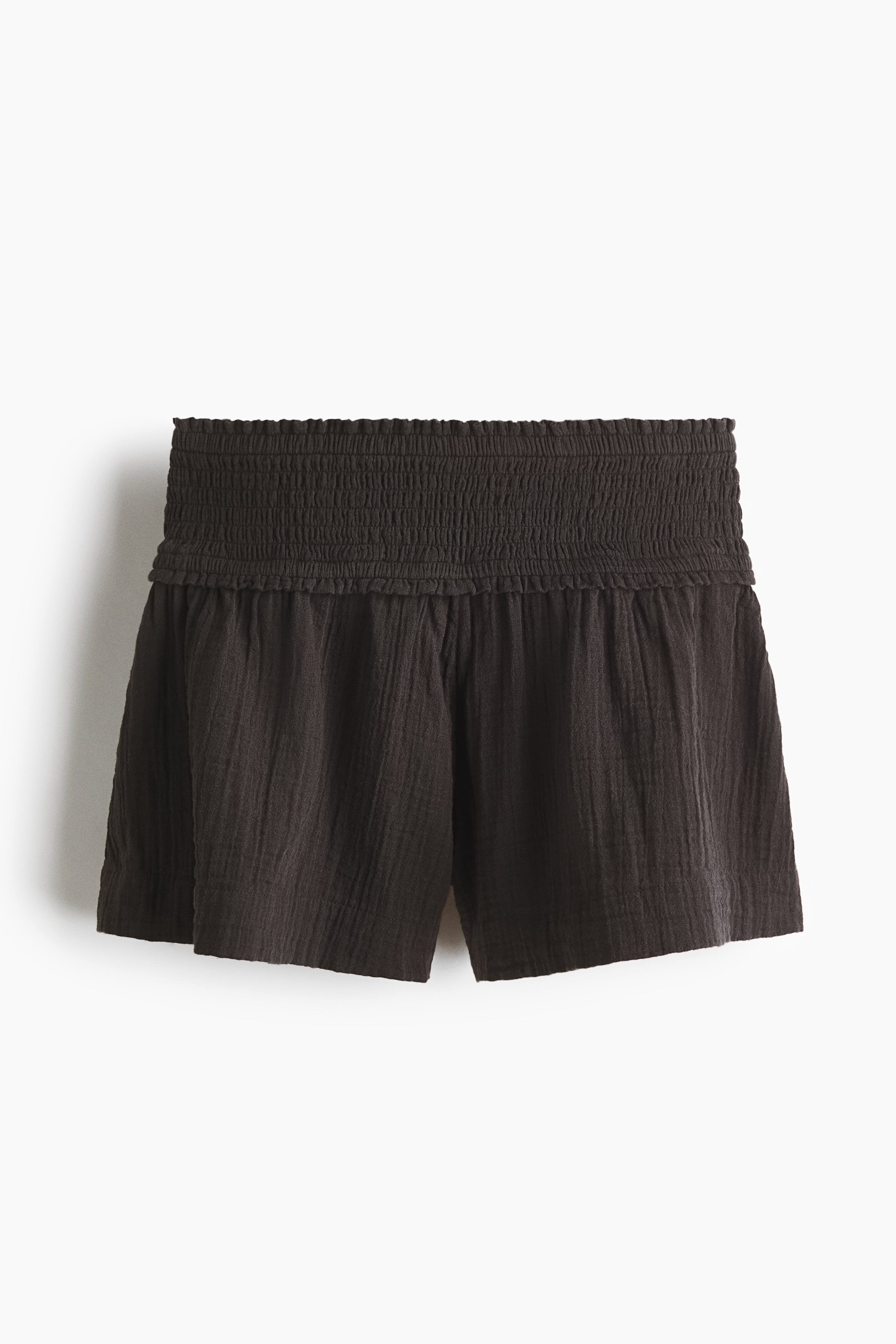 View larger image: Dark brown shorts are shown front-facing, featuring a wide, shirred waistband and a relaxed fit. The fabric displays a crinkled texture throughout.