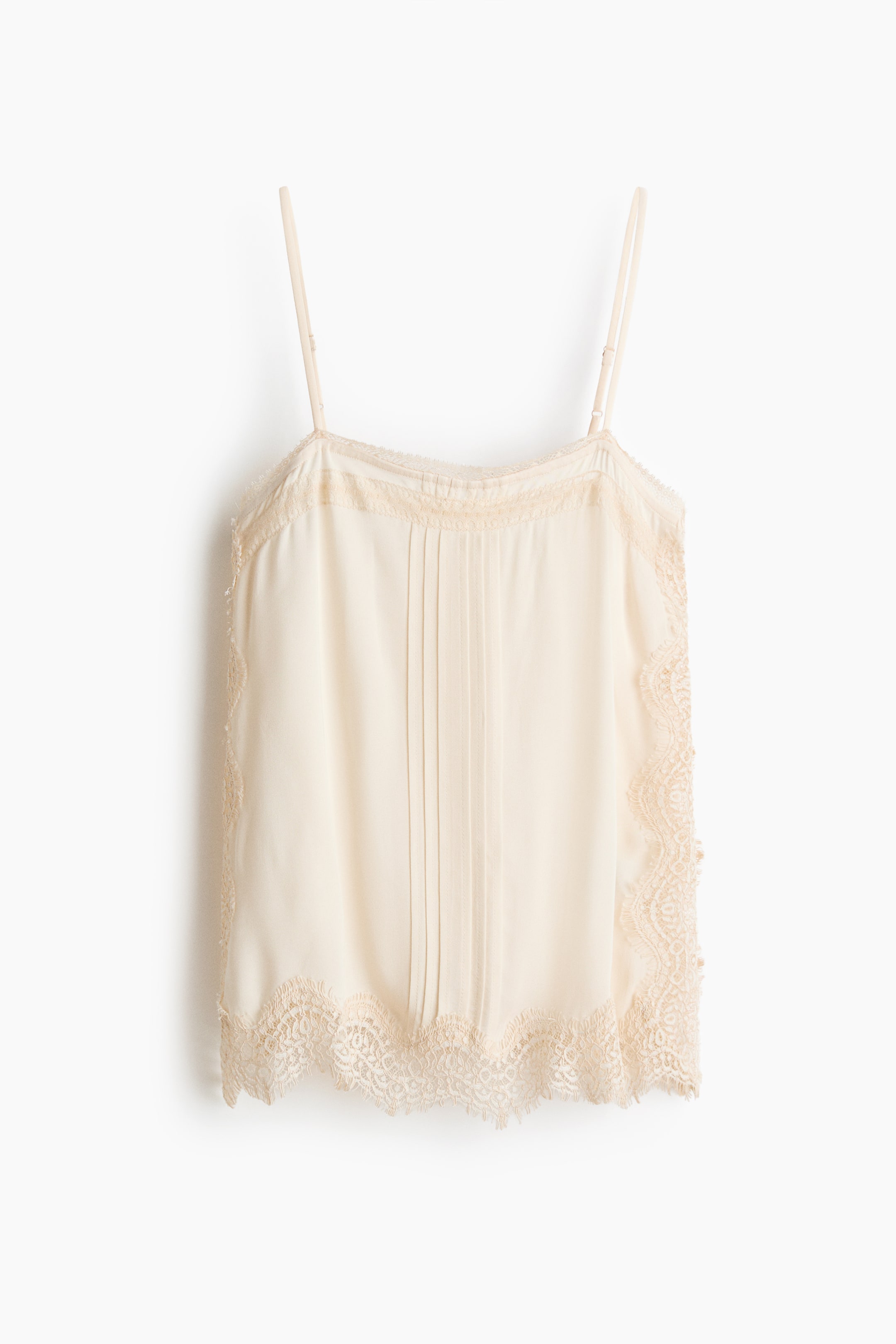 View larger image: A cream camisole is shown from the front, featuring thin adjustable spaghetti straps, vertical pintucks down the centre front, and scalloped lace trim adorning the neckline, side seams and hem.