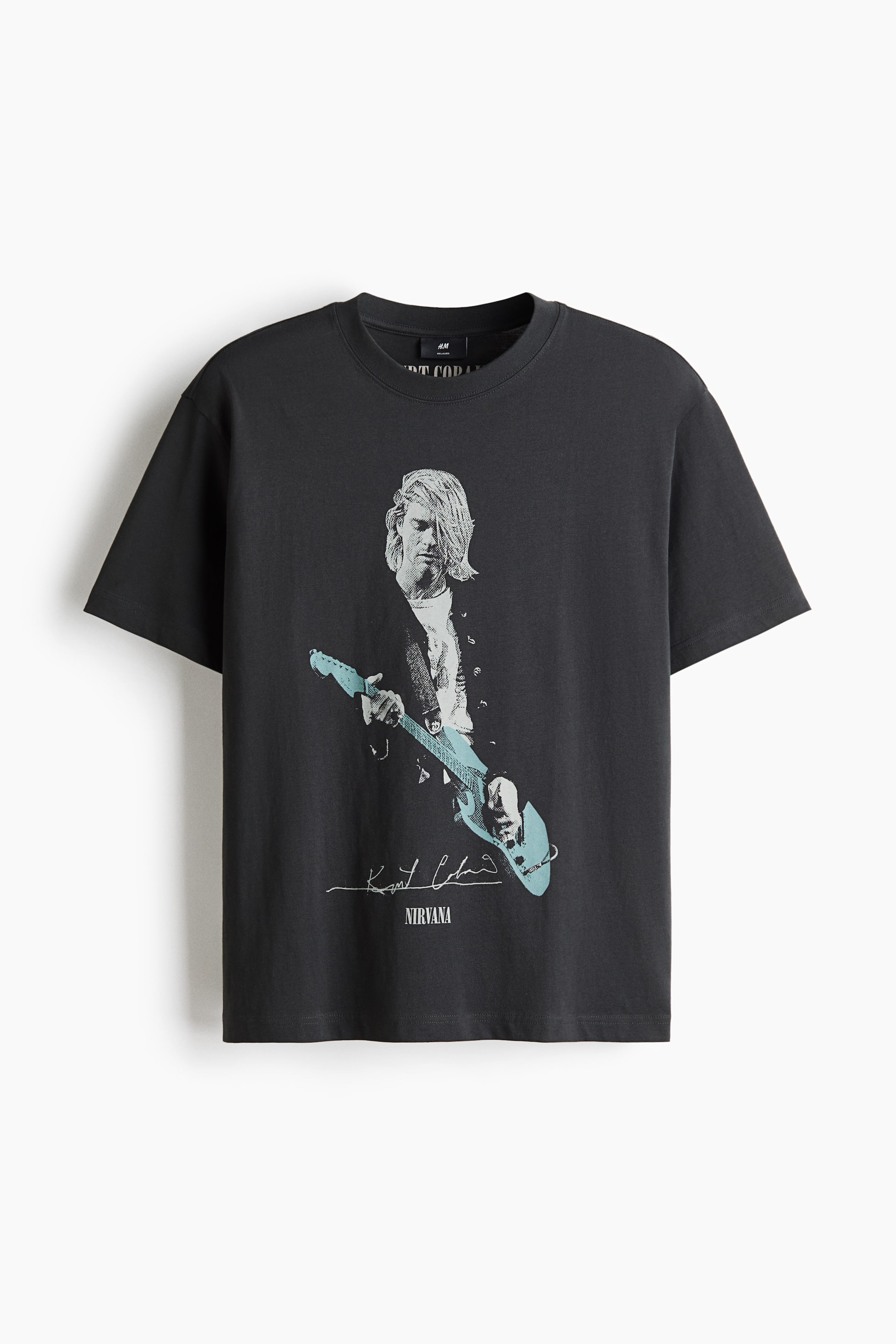 View larger image: A dark gray t-shirt with a round neck and short sleeves featuring a central graphic print of Kurt Cobain in black and white, holding a light blue guitar. Below the image, the text 'Kurt Cobain' and 'NIRVANA' is printed in white.
