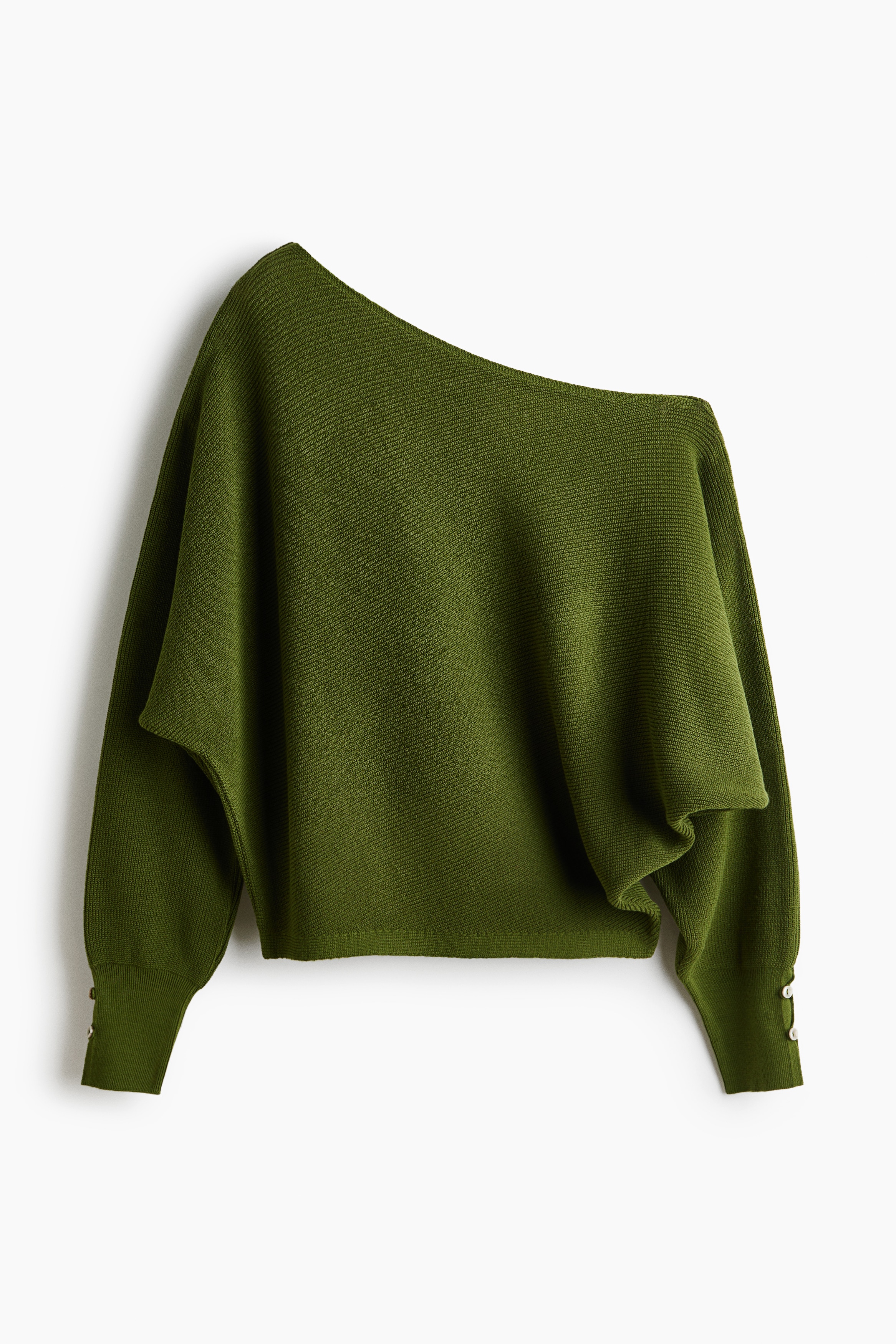La modelo lleva un jersey de punto verde oliva con escote asimÃ©trico y mangas largas de murciÃ©lago con puÃ±os de botÃ³n. El jersey de corte holgado se combina con un pantalÃ³n negro de pata ancha.