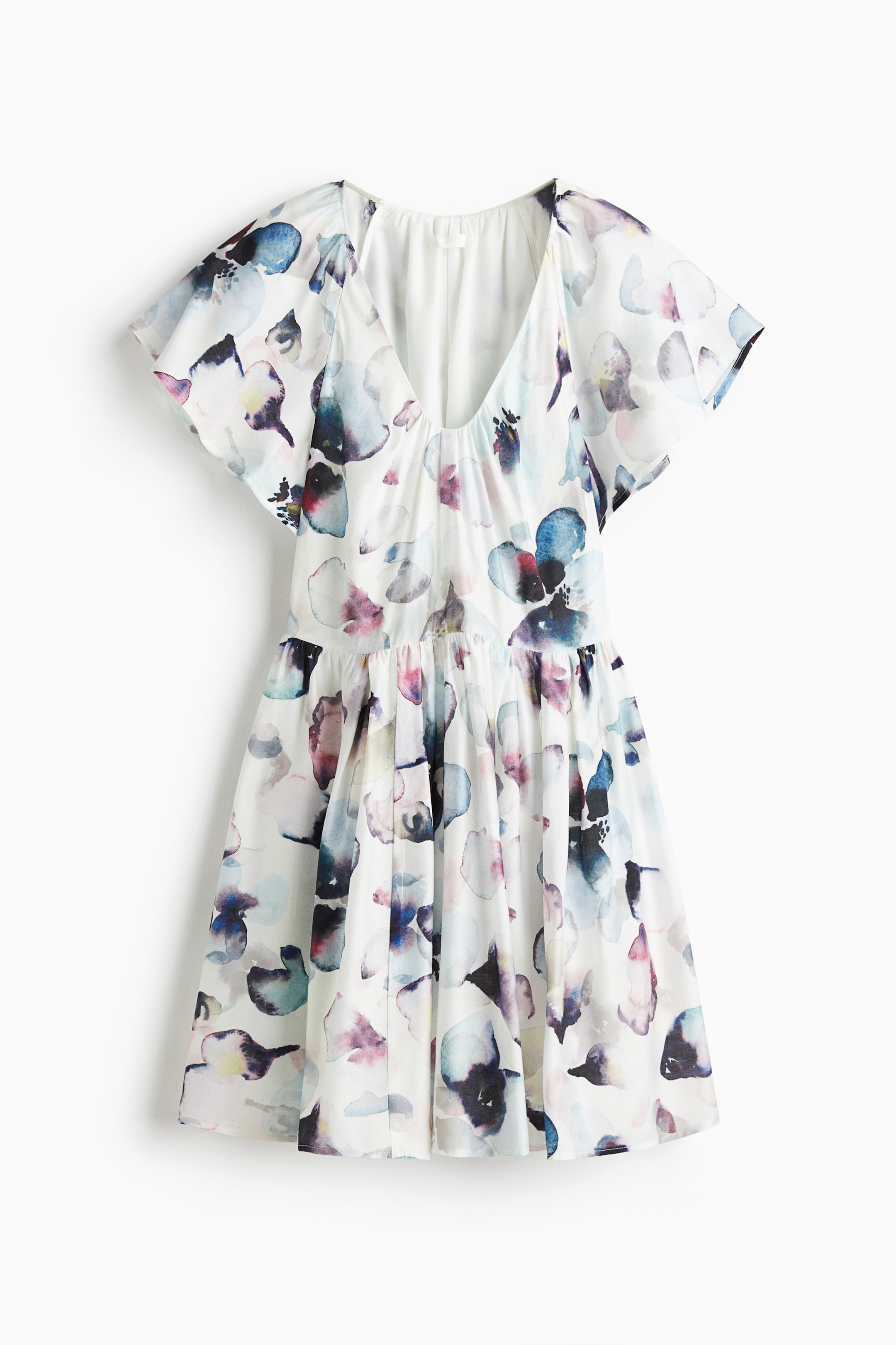 Xem ảnh lớn hơn: Một chiếc váy trắng phía trước đang trưng bày một họa tiết trừu tượng màu nước đa sắc. Nó được thiết kế với cổ chữ V sâu, tay áo ngắn xòe và eo được thu lại, chảy xuống thành một chiếc váy xòe.
