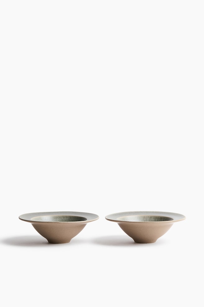 Deux bols en cÃ©ramique sont placÃ©s cÃ´te Ã  cÃ´te, orientÃ©s vers lâavant, prÃ©sentant un design conique Ã©vasÃ© avec de larges bords plats. Chaque bol affiche un extÃ©rieur mat, brun sable, contrastant avec un intÃ©rieur texturÃ© Ã©maillÃ© vert-gris. - 1