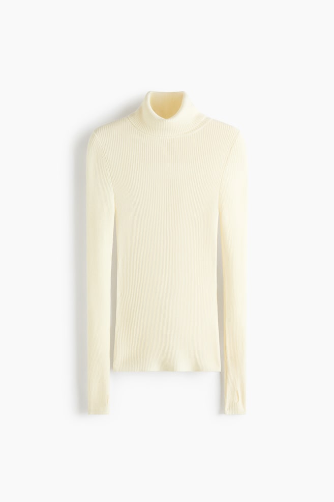A cream-colored, rib-knit turtleneck sweater is presenting a fitted silhouette with a high roll neck and long sleeves. The sweater is featuring a continuous vertical ribbed pattern throughout and includes subtle thumbhole details at the cuffs. - 1