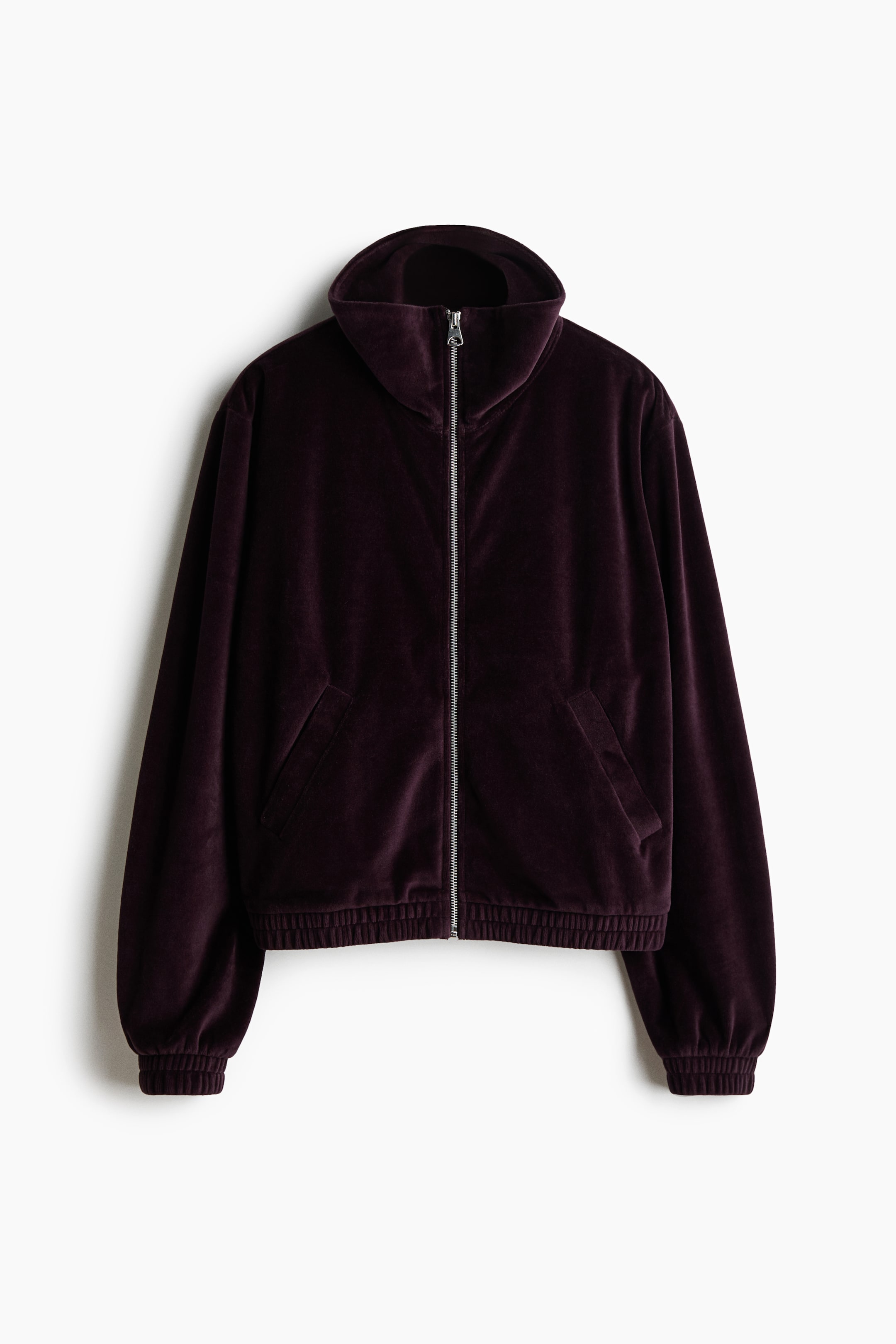 View larger image: A dark purple velvet jacket is shown from the front, with a high stand collar and a silver full-length zipper closure. It includes two front welt pockets and elasticized cuffs and hem.