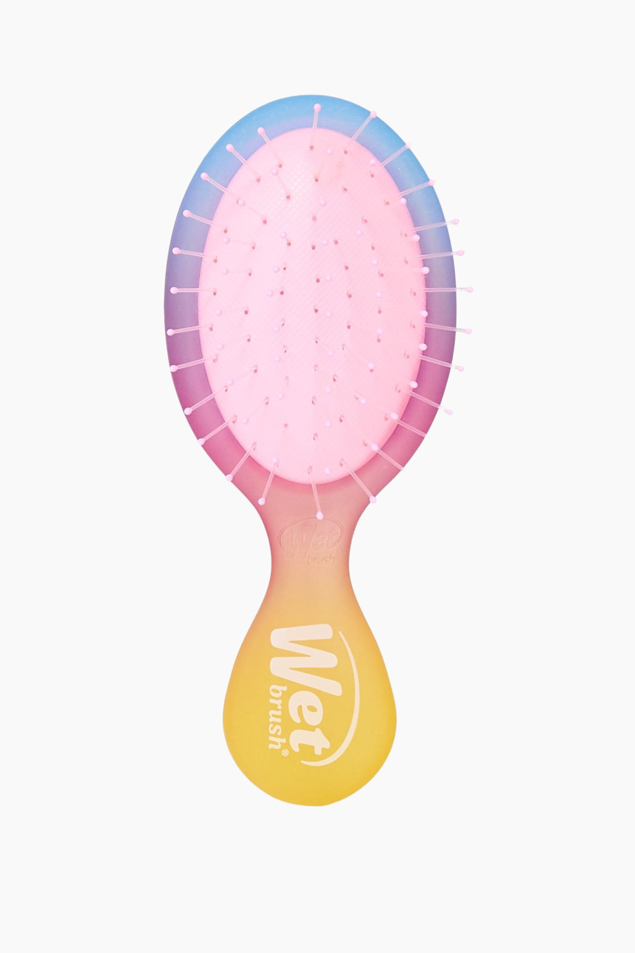 Näytä suurempi kuva: Hiusharja esittelee etupuoltaan, jossa on soikea harjaspää vaaleanpunaisella pohjalla, josta ulkonee lukuisia vaaleanpunaisia harjaksia, joista jokainen päättyy pieneen pyöristettyyn kärkeen. Harjaspään ulkoreuna näyttää värigradientin, joka vaihtuu sinisestä ylhäällä violettiin ja sitten vaaleanpunaiseen, sulautuen vaaleanpunaisen ja keltaisen sävyiseen varteen, jossa "Wet brush" -logo on näkyvissä valkoisena varren kaulassa ja suurempana keltaisessa osassa.