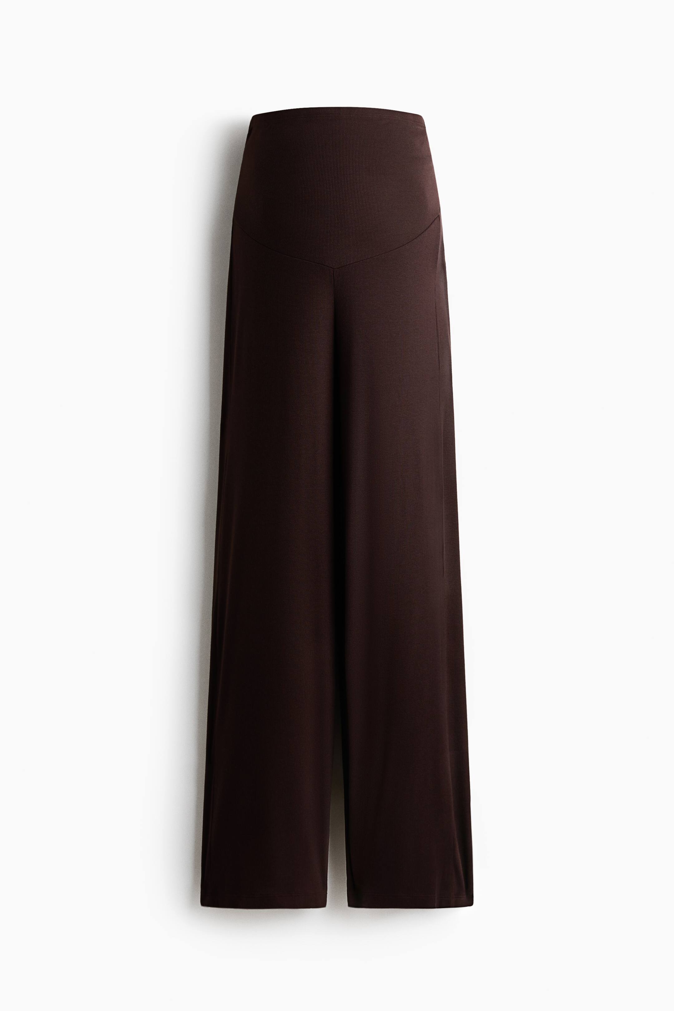 Größeres Bild anzeigen: Diese dunkelbraunen Wide-Leg-Hosen sind von vorne zu sehen und verfügen über einen hoch geschnittenen Bund mit einer geschwungenen Passe über den oberen Hüften. Der Stoff fällt fließend nach unten und formt eine weit ausgestellte Silhouette.