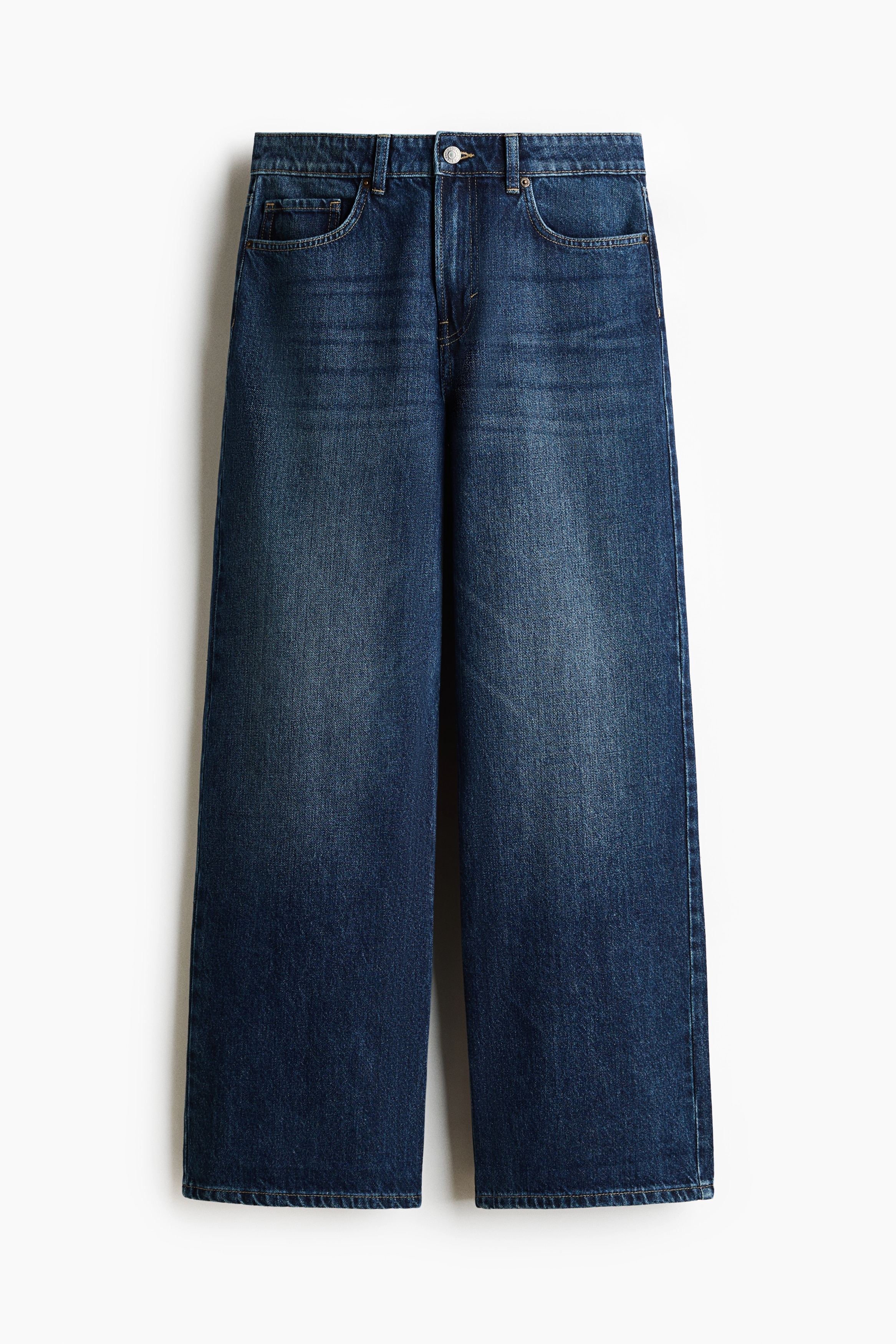 Dark blue, wide-leg denim jeans with a regular waist are being worn by the model, who is standing with her hands resting in the front pockets. The jeans are styled with a white ribbed tank top.