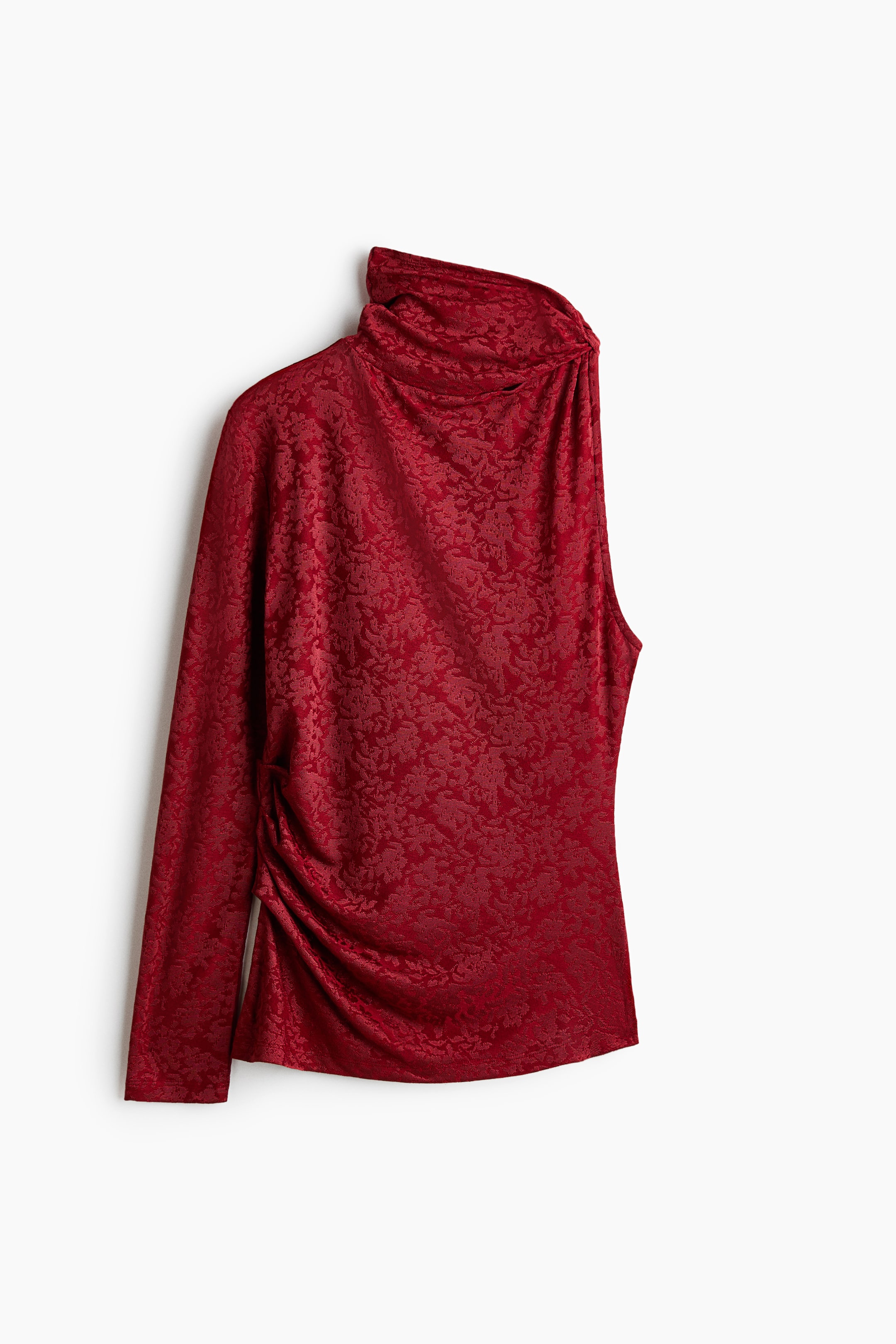 Visualizza immagine più grande: Questo top jacquard rosso, visto frontalmente, presenta un design asimmetrico monospalla con una singola manica lunga. Il top mostra un collo alto drappeggiato a cascata e dettagli arricciati raccolti lungo il fianco in vita.