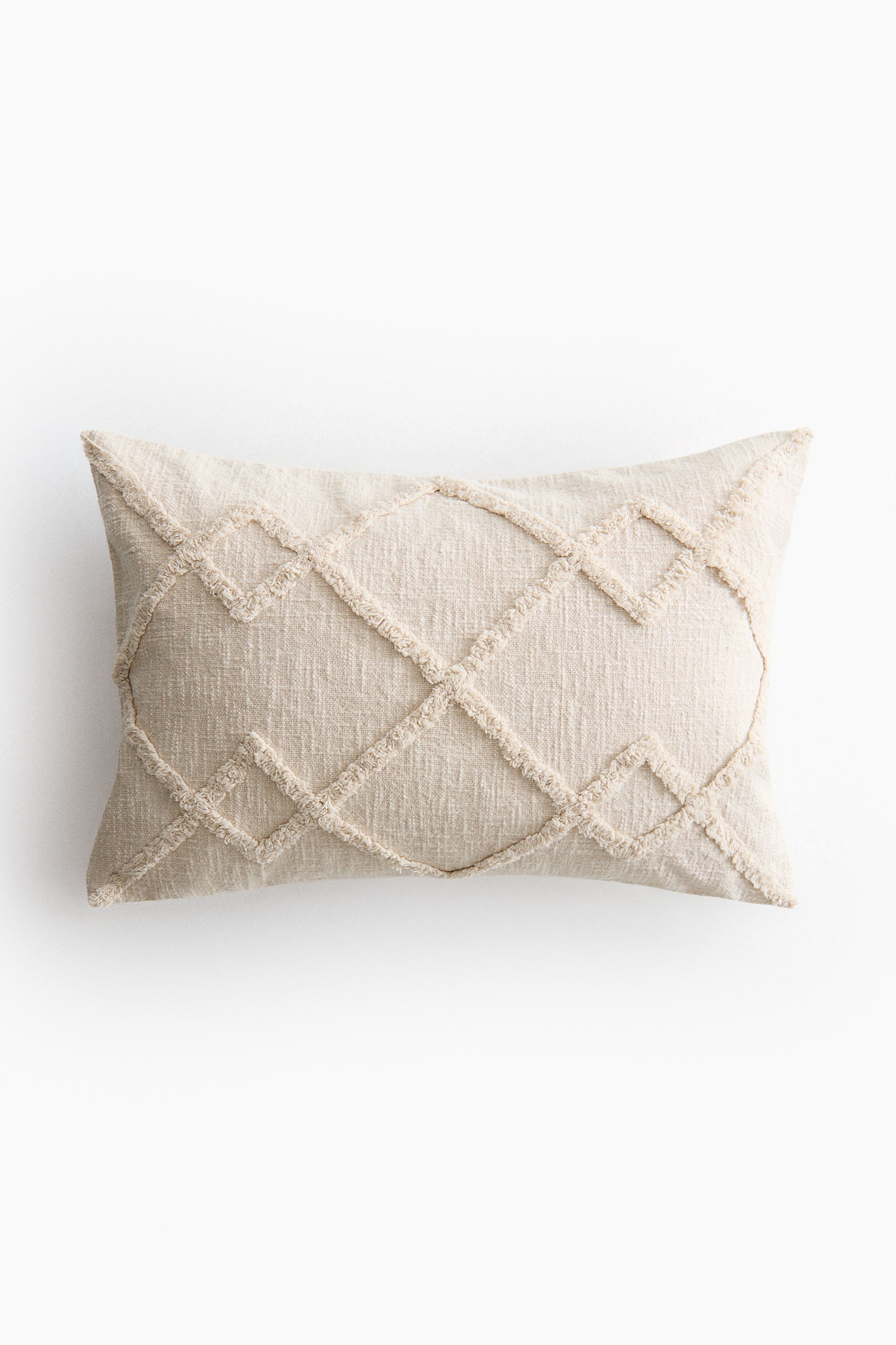 View larger image: A rectangular light beige cushion is displaying a geometric diamond pattern across its front. The pattern is formed by raised, textured, tufted lines on a woven fabric.