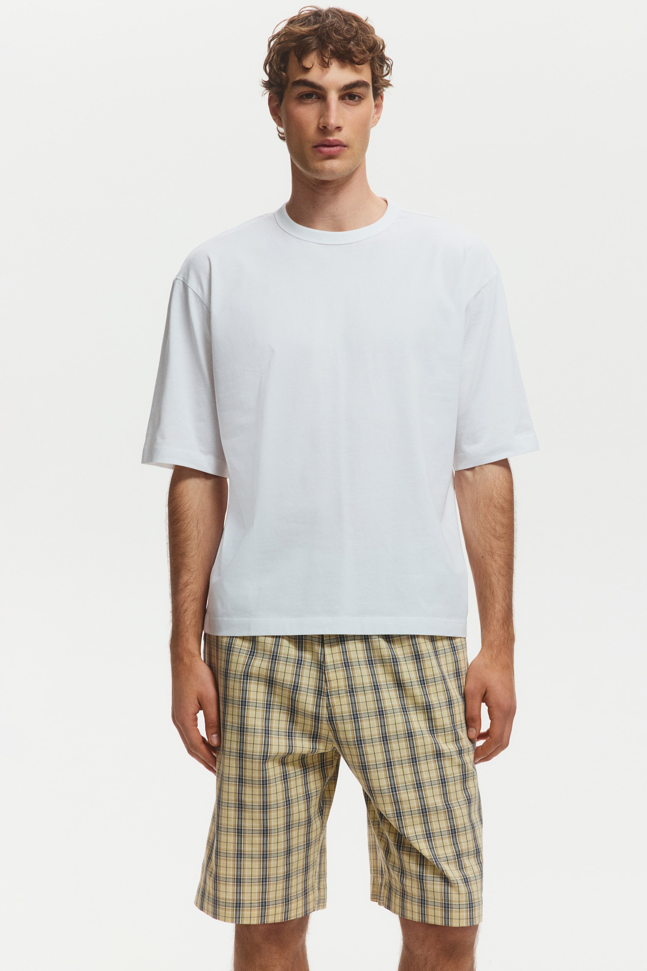 View larger image: A white short-sleeved t-shirt menampilkan leher bulat dan potongan santai, dengan lengan yang memanjang hingga ke pertengahan bisep, dipersembahkan dari sudut pandangan hadapan.