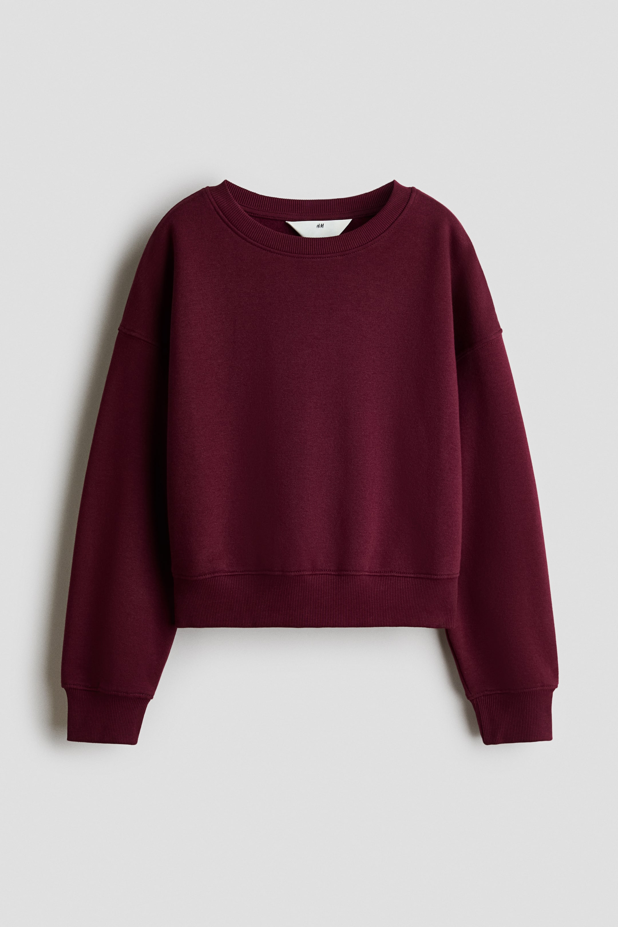 Ver imagen más grande: Sudadera de ajuste holgado en color burdeos, presentada de frente, con un cuello redondo ribeteado. Presenta hombros caídos, mangas largas y ribete en los puños y el dobladillo.