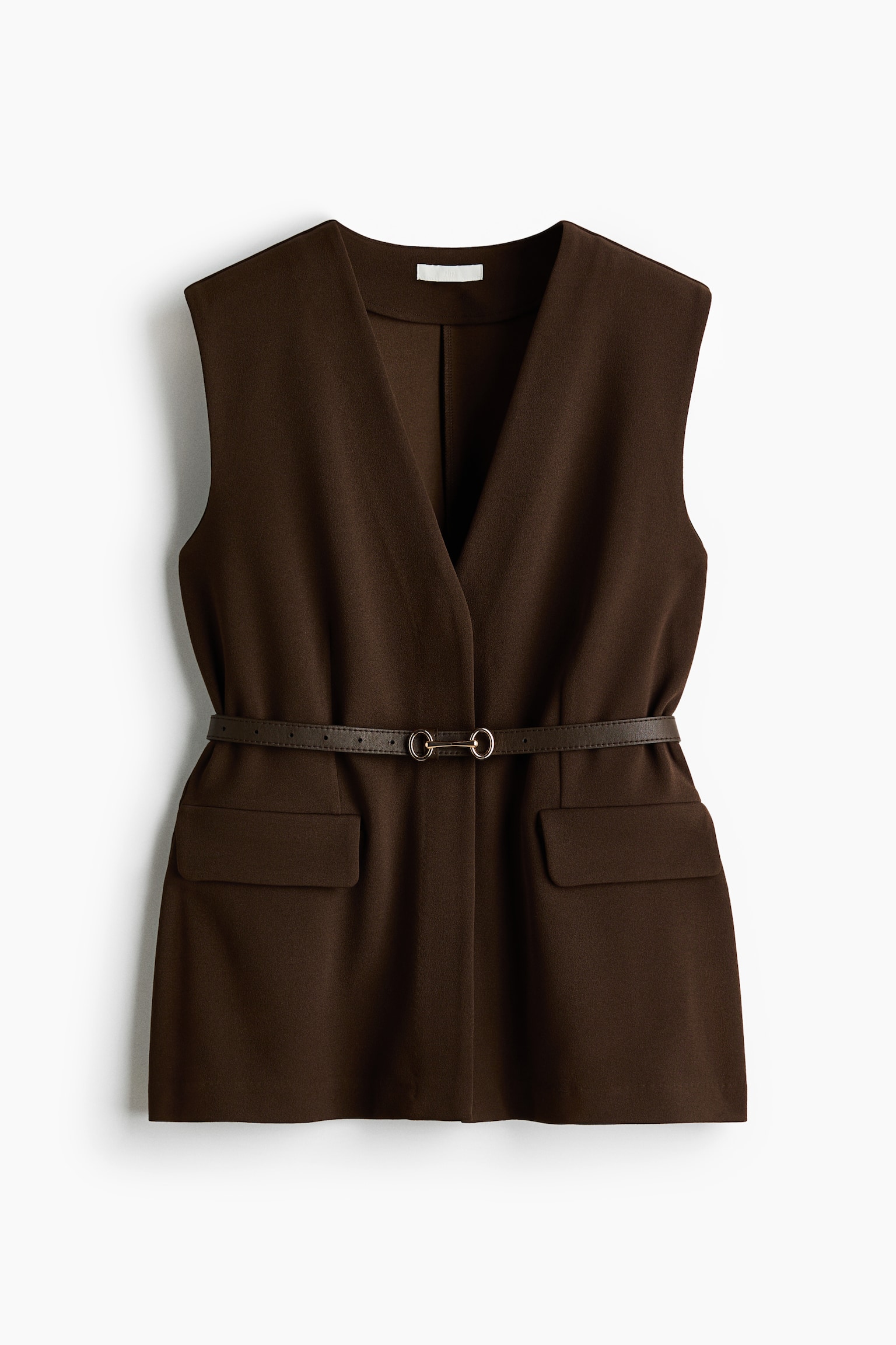 A dark brown sleeveless vest is displayed front-facing, showcasing a deep V-neck and overlapping front panels. It is cinched at the waist by a thin dark brown belt with a gold-toned double-ring buckle, and two patch pockets adorn the lower front. - 1