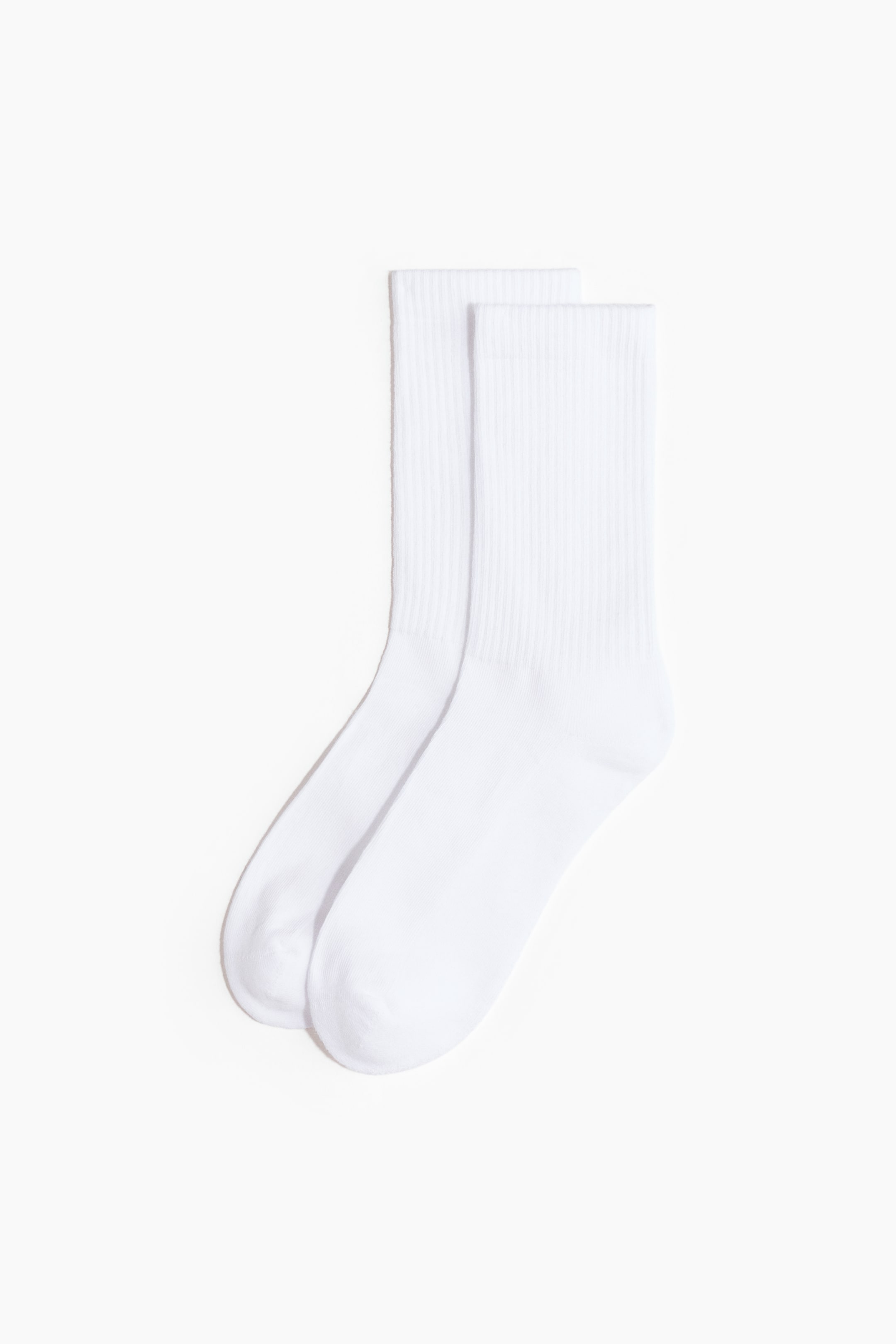 Visa större bild: Två vita ankelstrumpor med ribbade muddar och slätstickade fotpartier ligger platt och något överlappande.