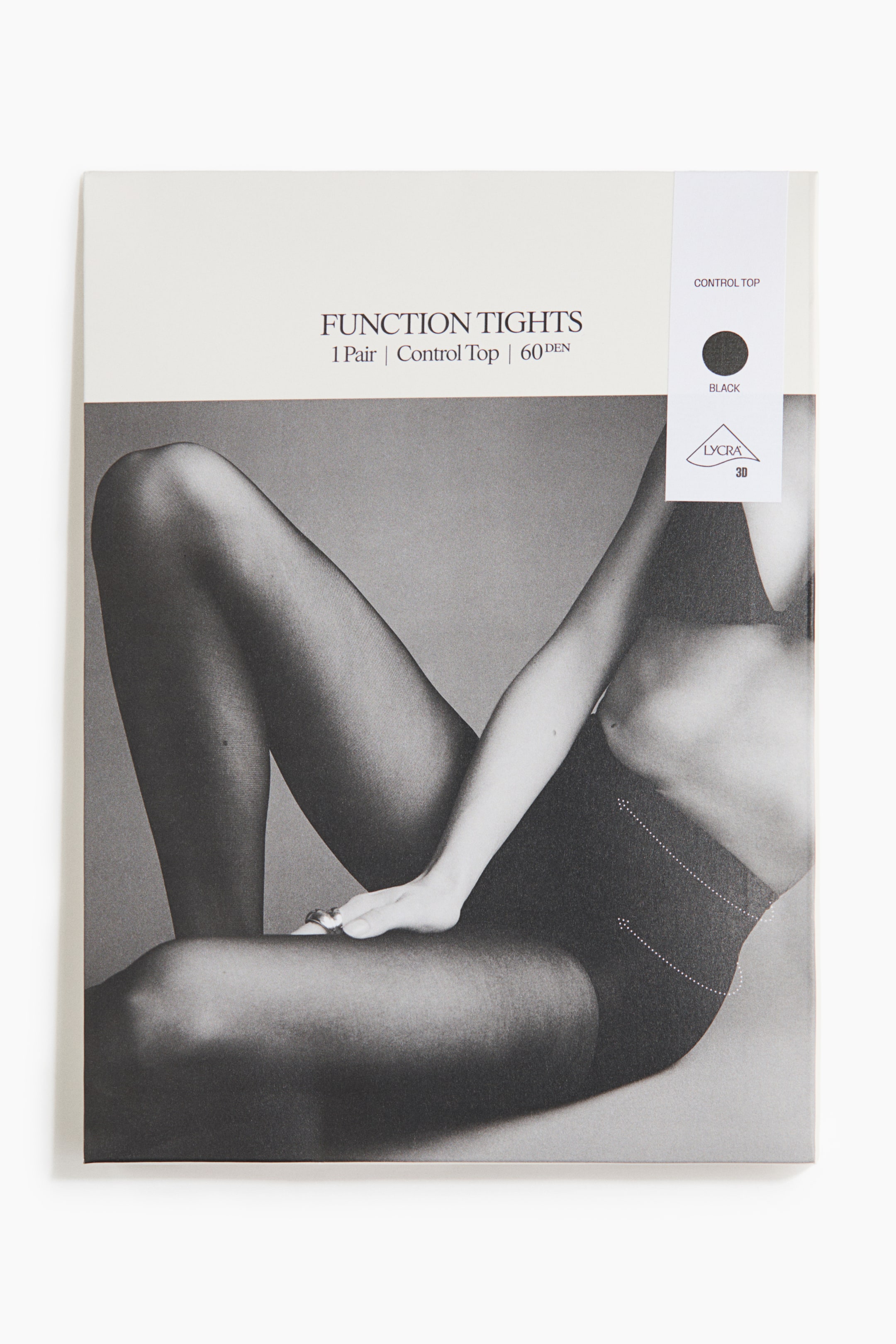 View larger image: The rectangular product packaging for 'Function Tights' features a black and white image of a person wearing black tights, with dotted lines illustrating the 'Control Top' area. The packaging also displays text details including '1 Pair | Control Top | 60 DEN', a 'Lycra 3D' logo, and a black colour swatch.