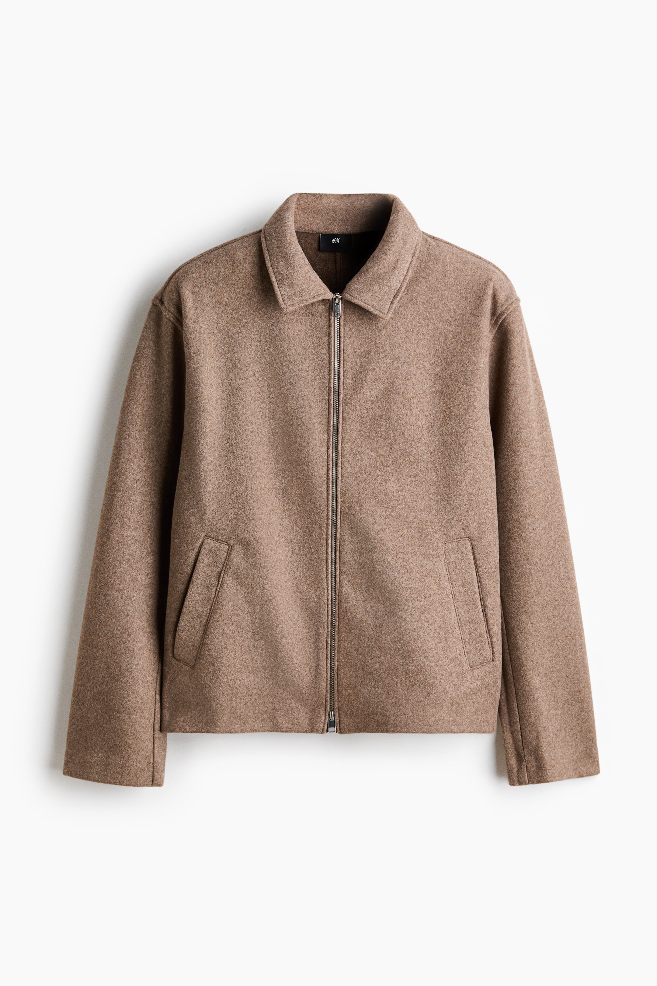 Größeres Bild ansehen: Die hellbraune Jacke wird von vorne präsentiert und verfügt über ein strukturiertes Gewebe. Sie zeigt einen durchgehenden Reißverschluss in Silberoptik, einen klassischen Kentkragen sowie zwei schräge Leistentaschen im unteren vorderen Bereich.