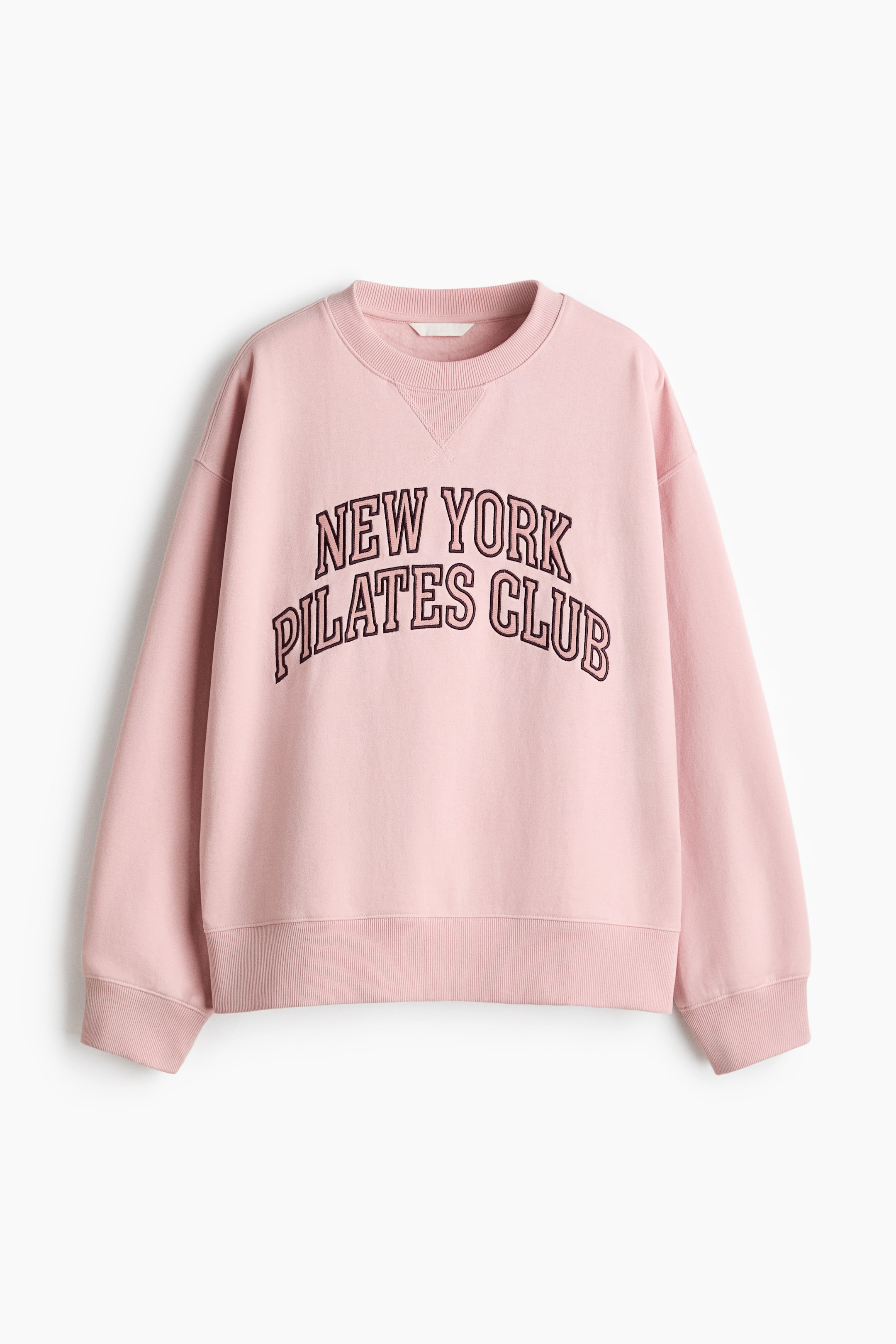 Agrandir l'image: Un sweat-shirt oversize rose est présenté de FACE, avec un motif "NEW YORK PILATES CLUB" sur la poitrine. Il est conçu avec un col rond à finition côtelée, des épaules tombantes, des manches longues et des poignets et ourlet côtelés.
