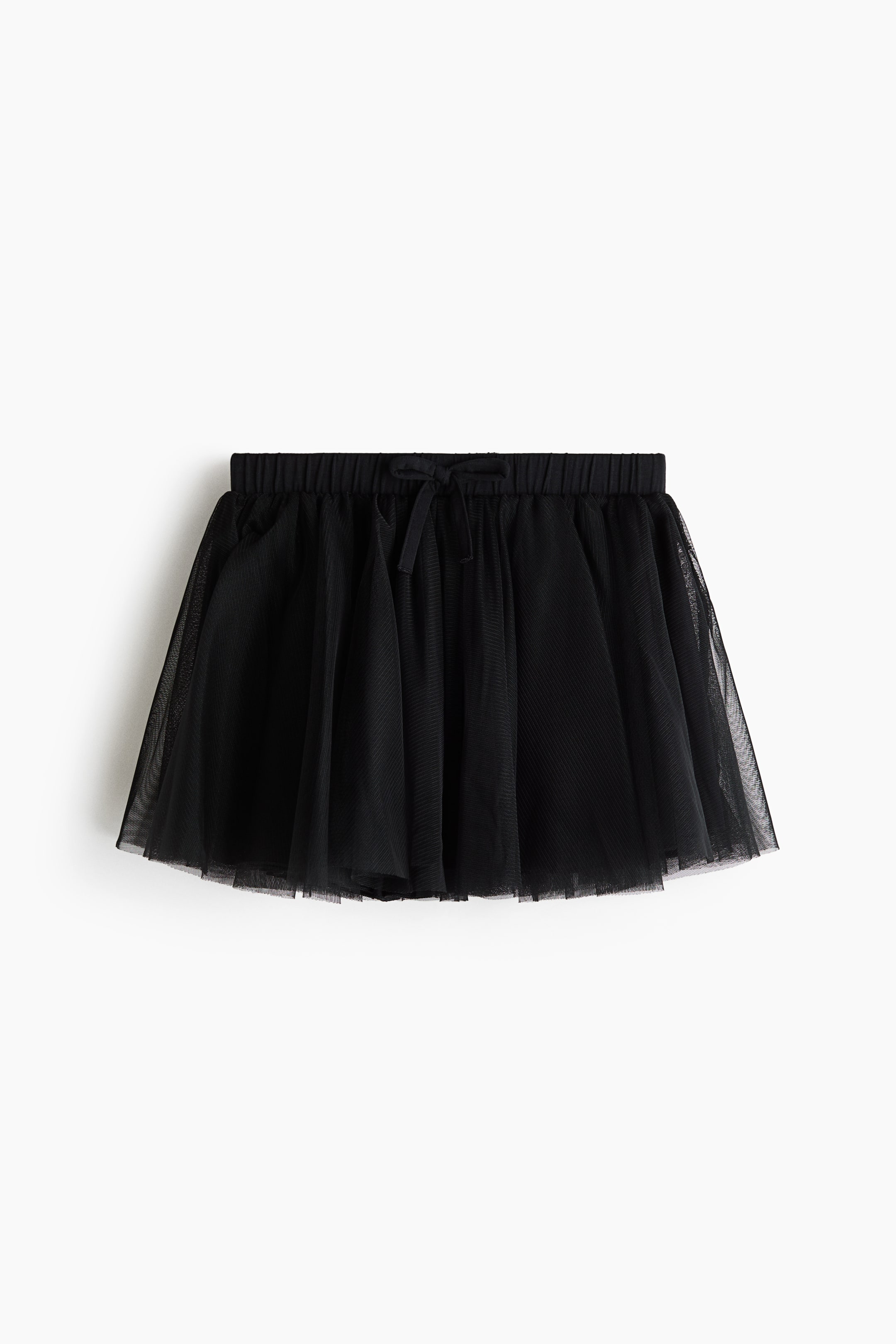 Grotere afbeelding bekijken: Een zwarte dansrok van mesh is van voren afgebeeld, met een elastische tailleband en een klein decoratief strikje dat in het midden is vastgenaaid. De rok toont geplooide lagen transparante mesh over een effen zwarte voering, wat zorgt voor een uitlopend silhouet.