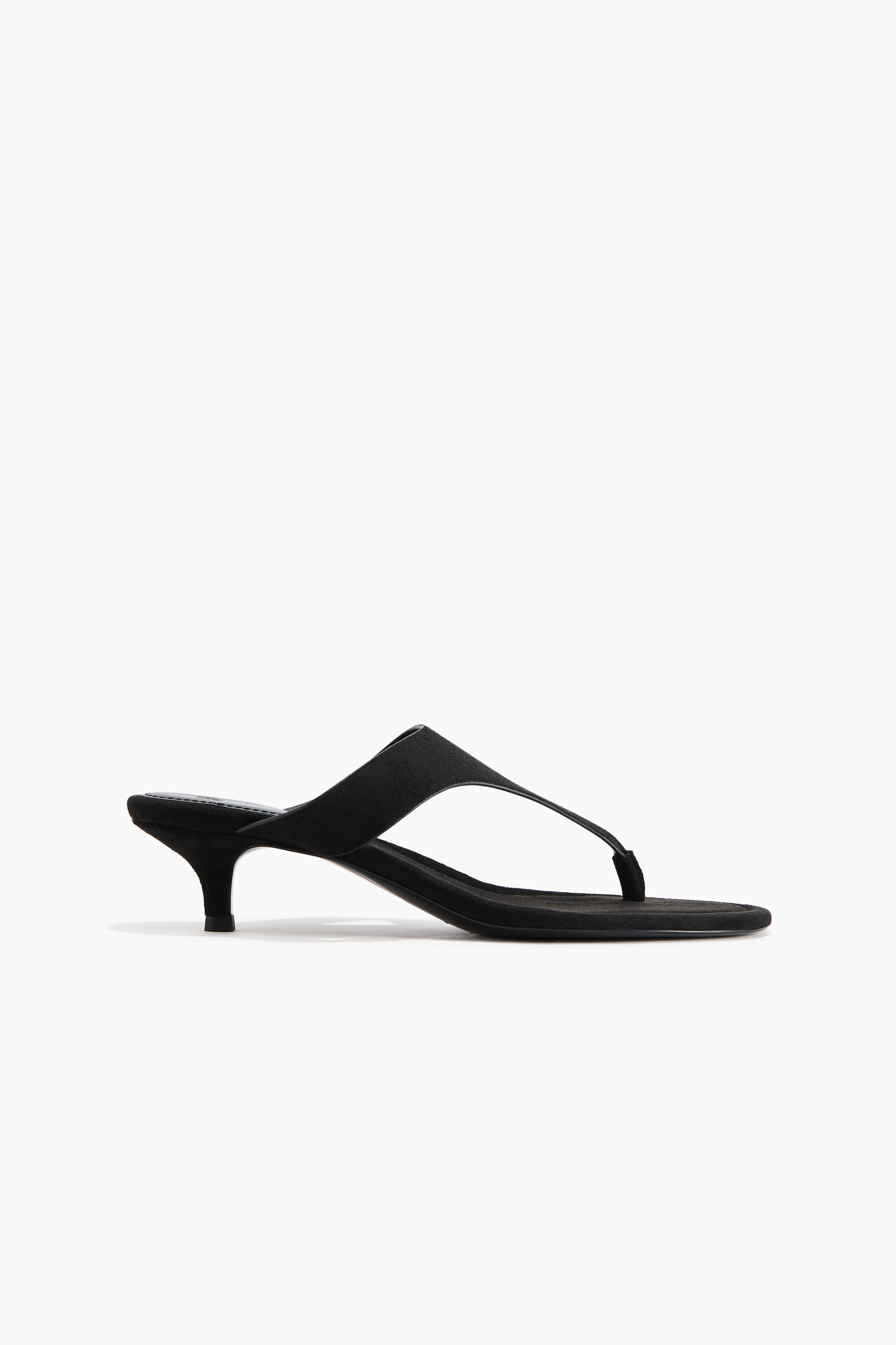Visa större bild: Svarta sandaler med en mjuk, borstad finish, snedställda tår, en smal fotrem och en tårem, vilande på delvis täckta kitten-klackar.
