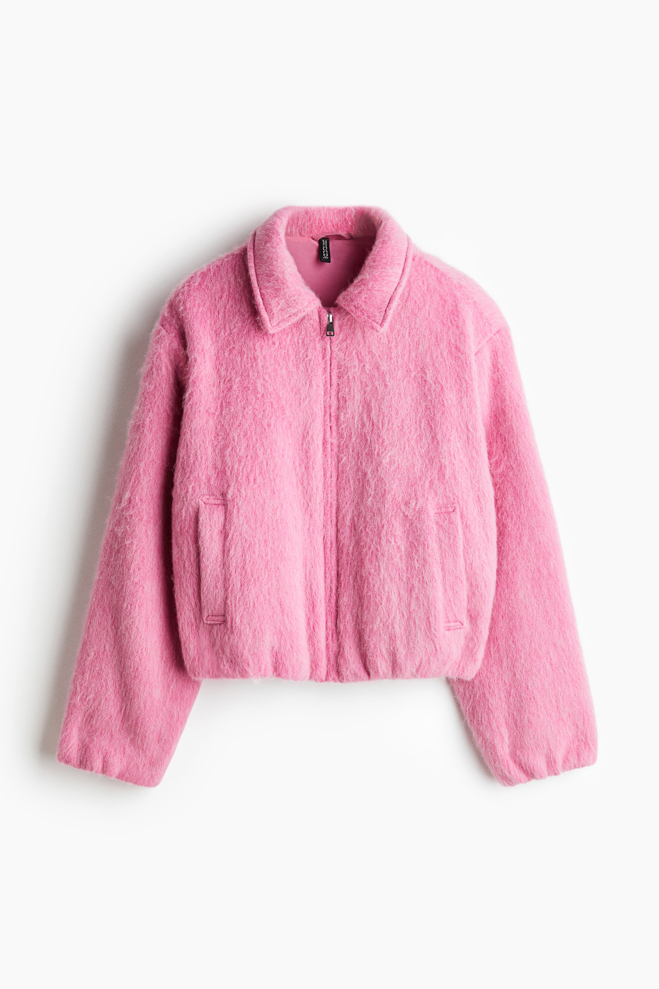 Agrandir l'image: DEVANT. Une veste texturée rose et duveteuse est dotée d'un col pointu et d'une fermeture éclair complète. Elle présente deux poches plaquées à l'avant et un ourlet élastiqué.