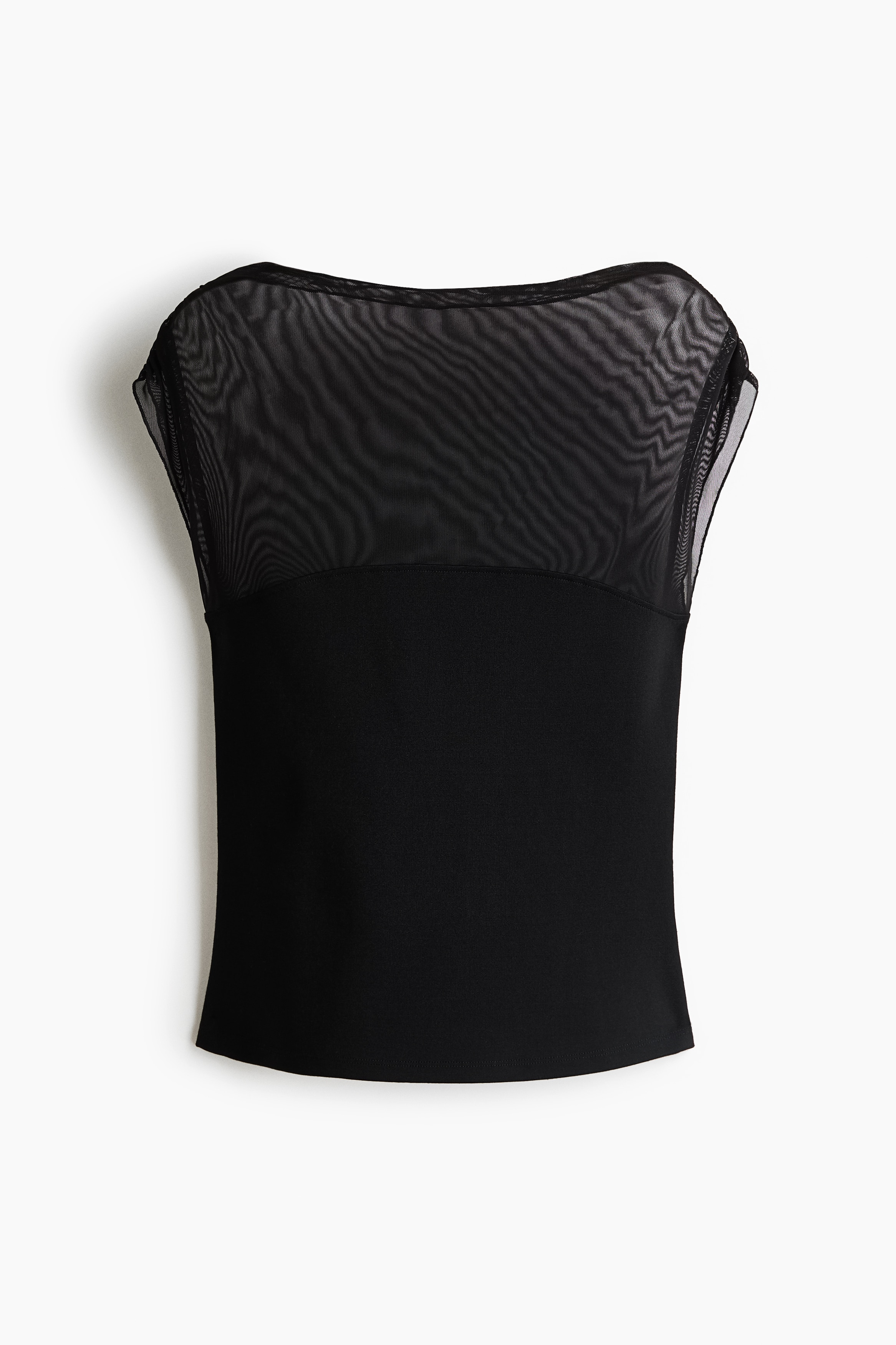 A black fitted top featuring a sheer mesh upper panel, a boat neckline, and cap sleeves is worn by the model. The top is styled with a tiered, ruffled black mini skirt with white polka dots.