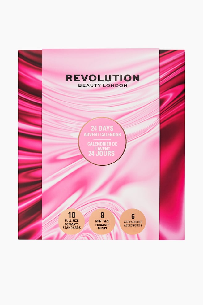 Adventskalenderen 2026 viser en frontvendt visning av en firkantet eske med et livlig, rosa og magenta virvlende satengmønster. Forsiden viser merkenavnet «REVOLUTION BEAUTY LONDON» øverst, en sentral rosa sirkel som fremhever «24 DAYS ADVENT CALENDAR», og tre mindre tan-fargede sirkler nederst som angir innholdets fordeling. - 1