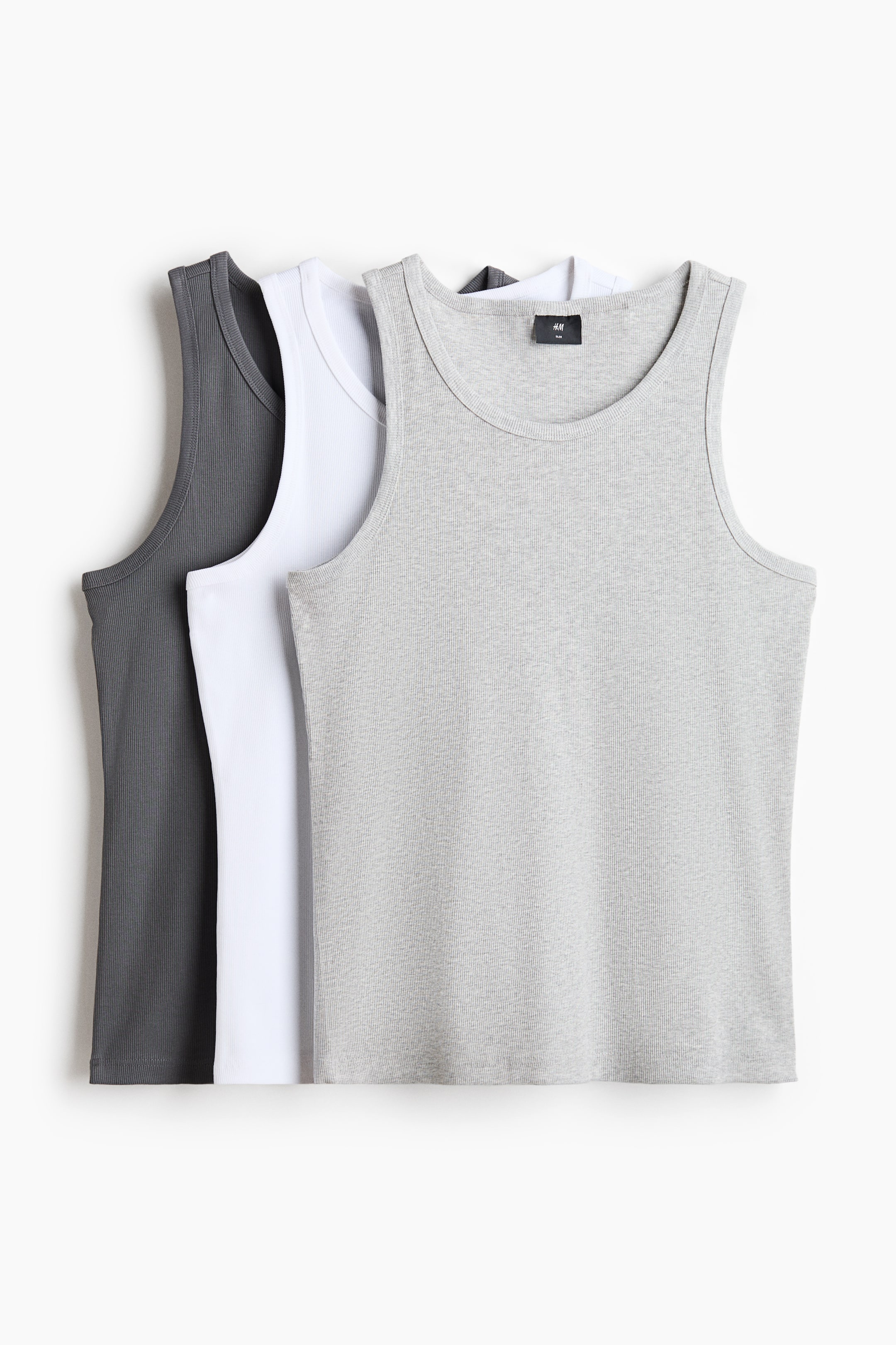 View larger image: Three tank tops are shown from the front, featuring one in light gray, one in white, and one in dark gray, all layered together. They showcase a ribbed jersey texture, a round neckline, and a straight-cut hem, crafted with a slim fit.