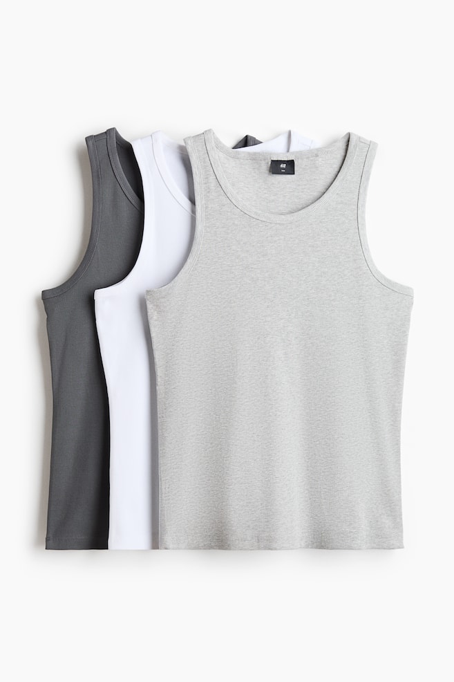 Three vest tops are facing front, with one light gray, one white, and one dark gray top layered together. They are displaying a ribbed jersey texture, a round neckline, and a straight-cut hem, designed with a slim fit. - 1