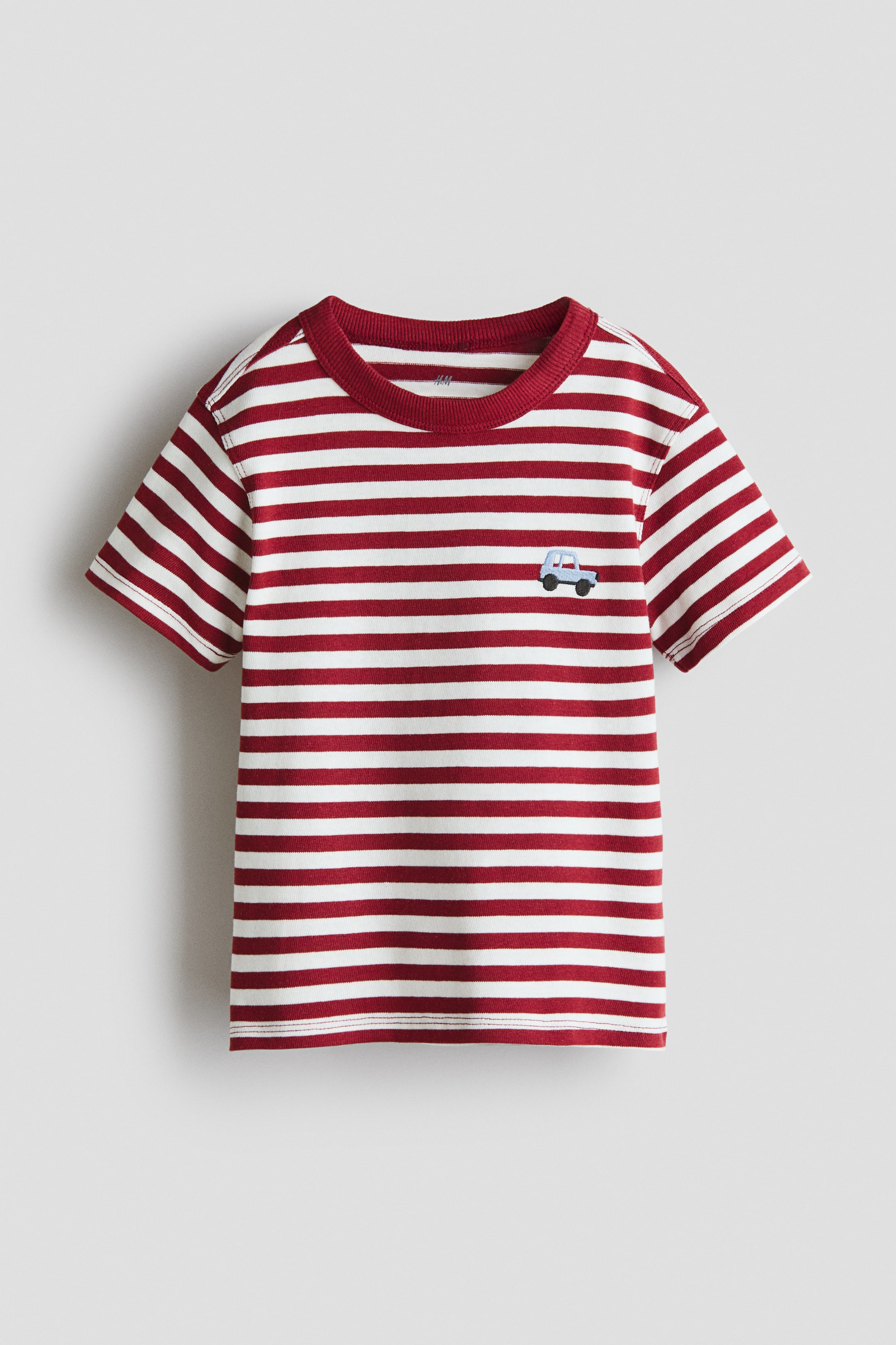 View larger image: The t-shirt showcases red and white horizontal stripes on its front. It features a solid red ribbed crew neck, short sleeves, and a small light blue embroidered car on the left chest.