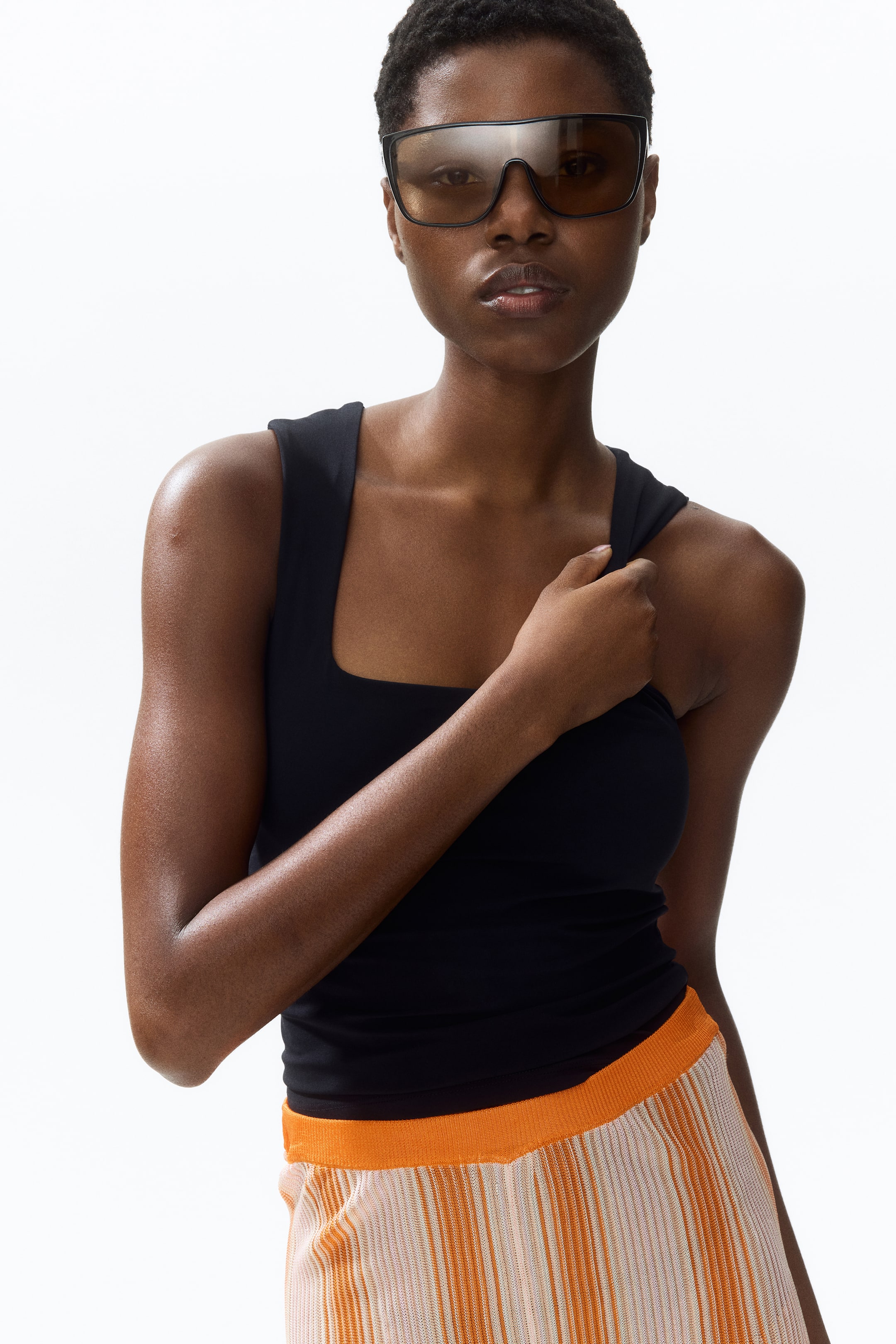View larger image: The black tank top showcases a square neckline, wide shoulder straps, and a fitted silhouette with a smooth fabric texture.