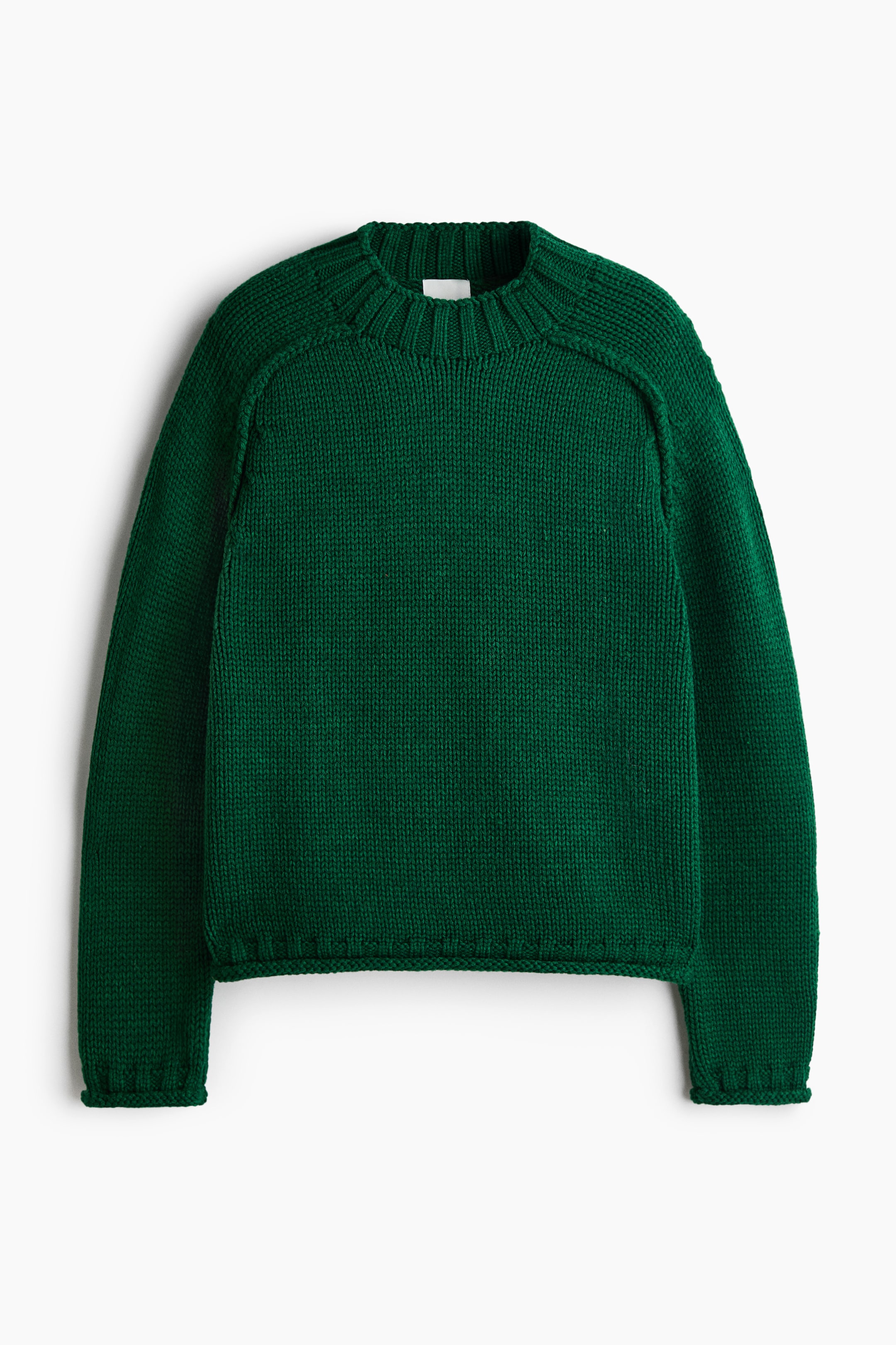 Größeres Bild ansehen: Ein dunkelgrüner Strickpullover ist von vorne zu sehen und präsentiert ein grobes glatt rechts gestricktes Design mit Raglanärmeln. Er verfügt über einen dicken gerippten Rundhalsausschnitt, gerippte Bündchen und einen dazu passenden gerippten Saum.