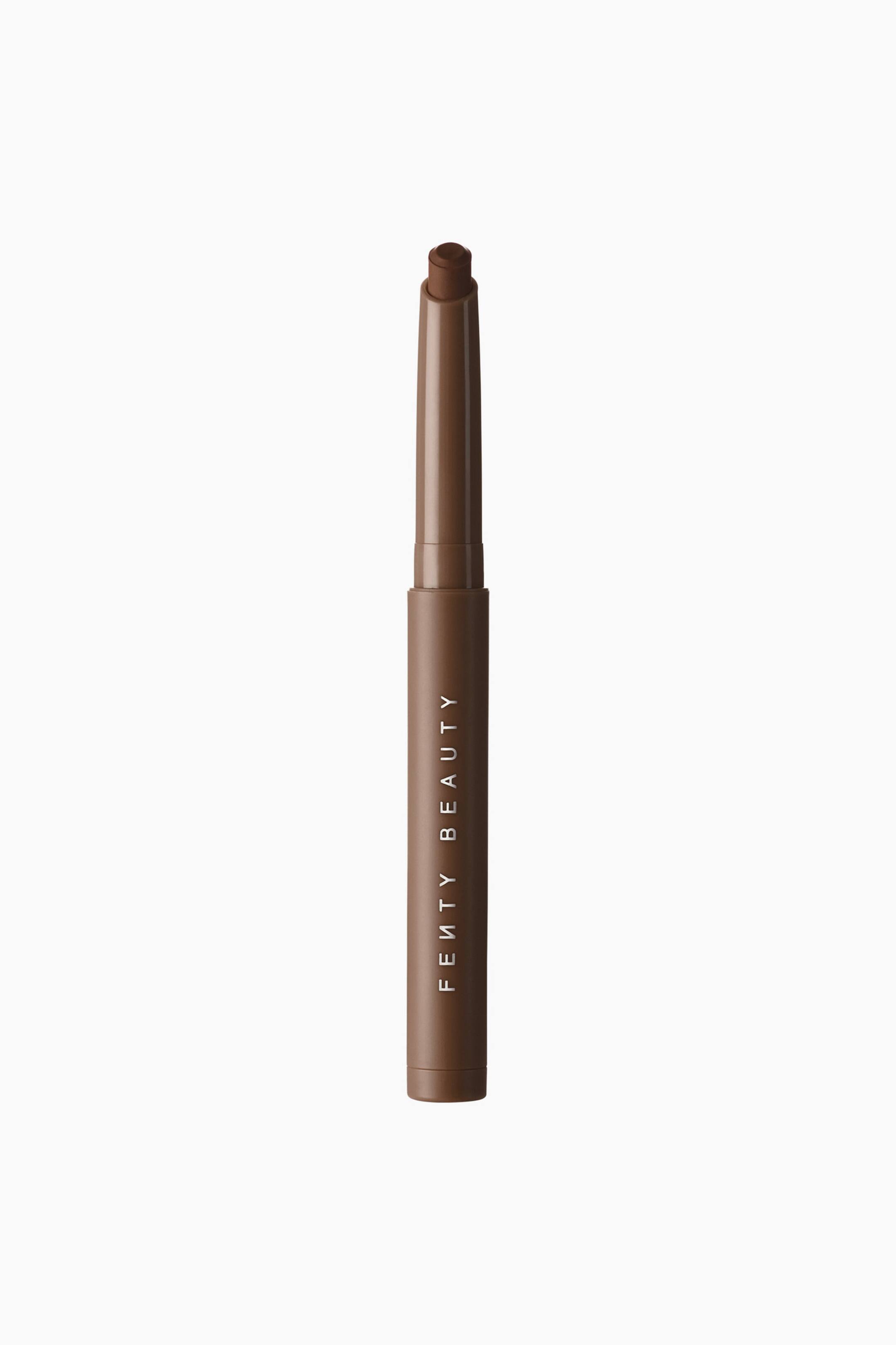Se større billede: Shadowstix Longwear Eyeshadow Stick står lodret og viser sit slanke, cylindriske matte brune hylster med brandnavnet trykt lodret i hvidt. Hætten er taget af og afslører den skråt afskårne spids på den mørkebrune øjenskygge.