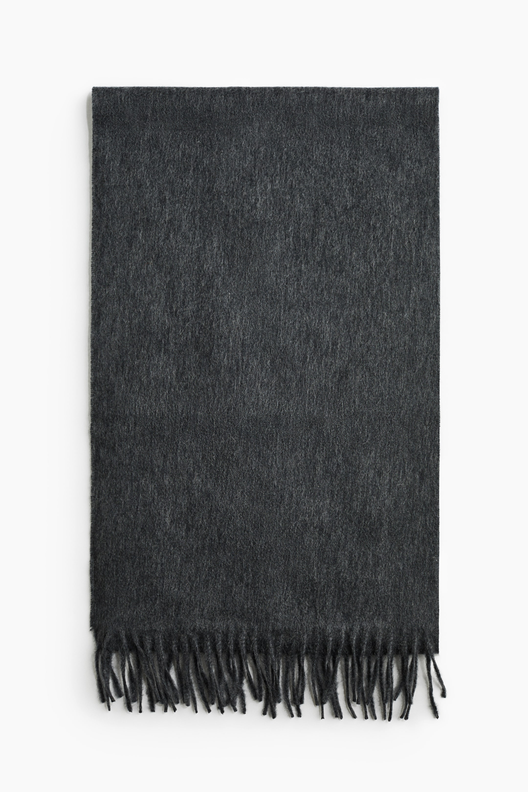 View larger image: A dark grey cashmere scarf is shown front-on, lying flat to display its soft, brushed texture. The scarf features twisted fringe detailing along the visible bottom edge.