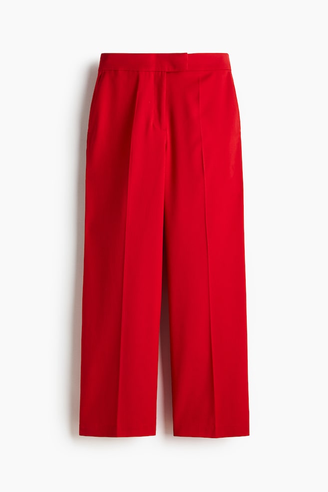 Red trousers in woven fabric are presenting from the FRONT, featuring an extended waistband with a concealed hook-and-bar fastening and a zip fly. Diagonal side pockets are subtly visible, and straight legs with creases are extending down the front. - 1