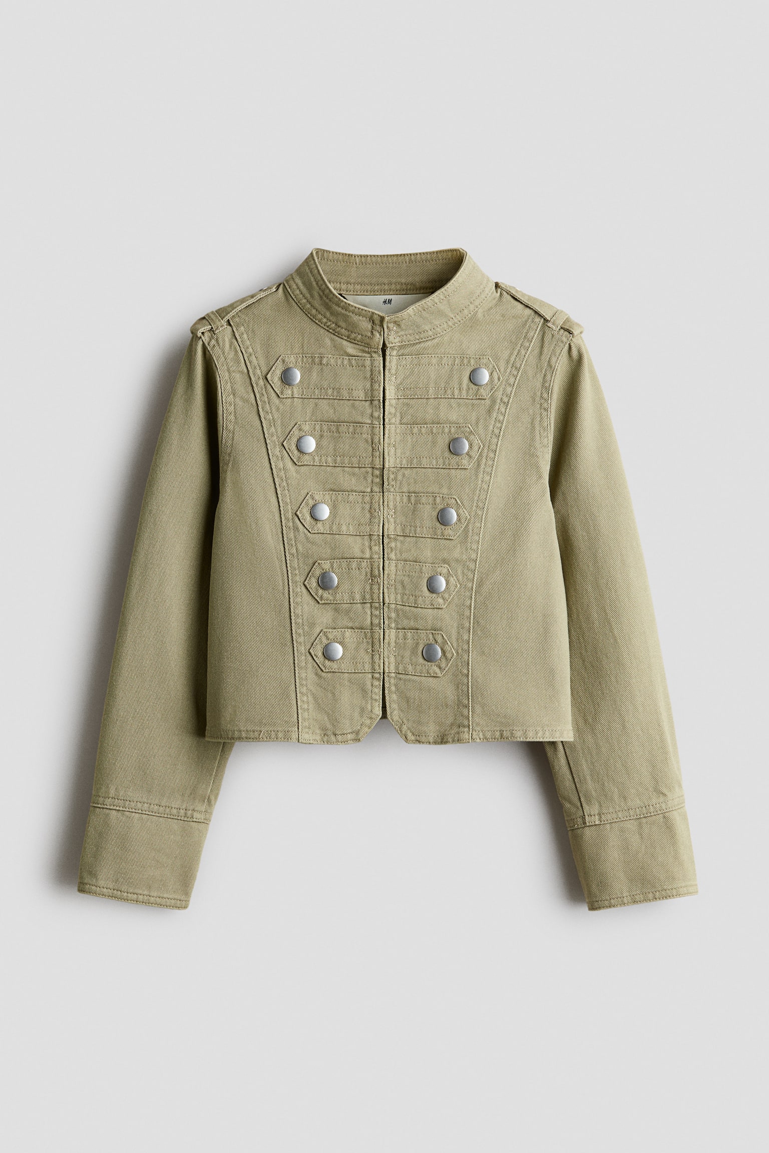 This cropped jacket in olive-green cotton twill showcases a military-inspired design from the front, featuring a small stand collar and a concealed front closure. It features five sewn-on, studded tabs with silver-tone studs on each side of the chest, along with shoulder tabs and long sleeves with wide cuffs. - 1