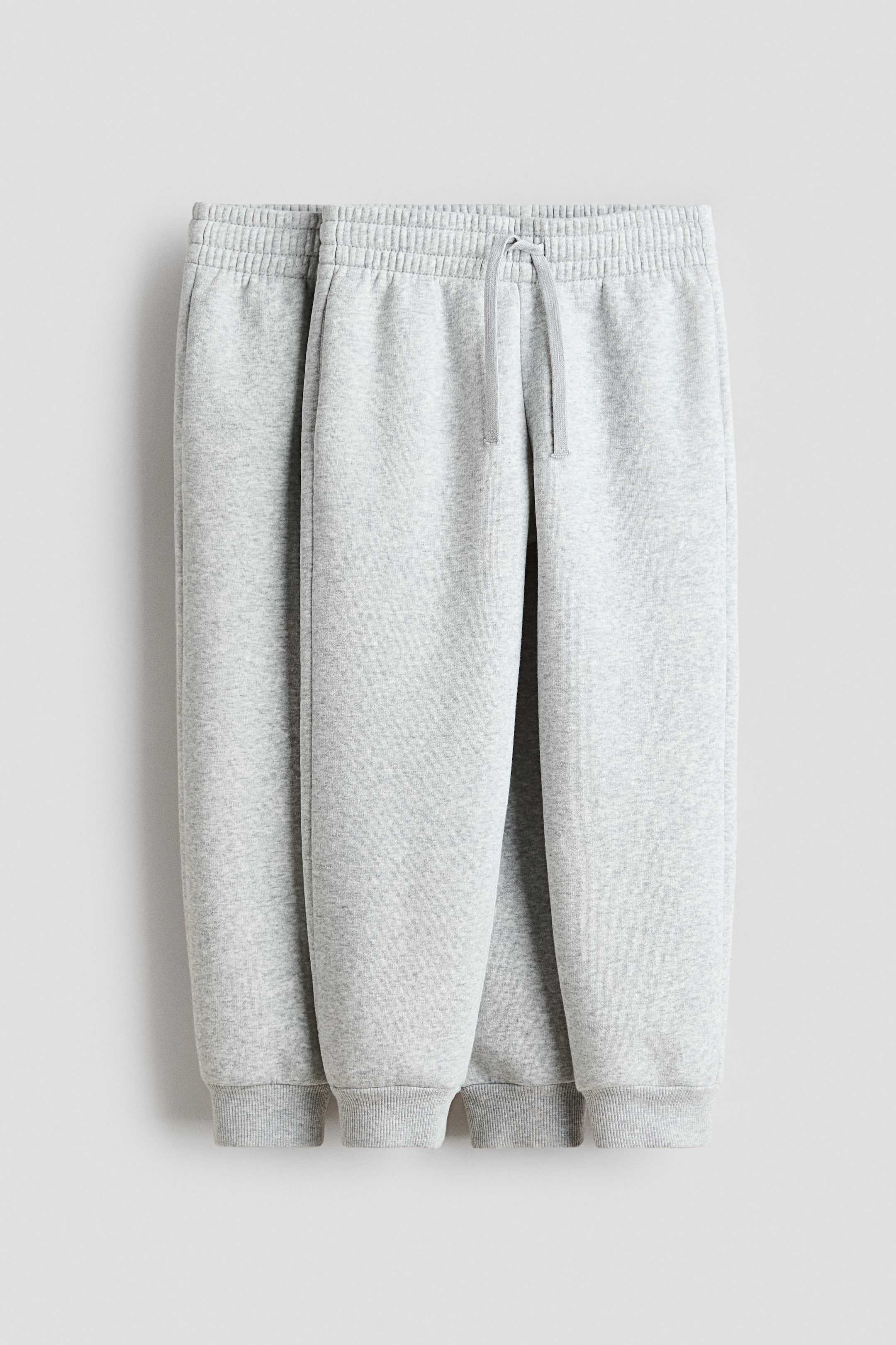 View larger image: Light grey marl joggers shown from the front, featuring an elasticated drawstring waist, side pockets and ribbed cuffs at the hems.