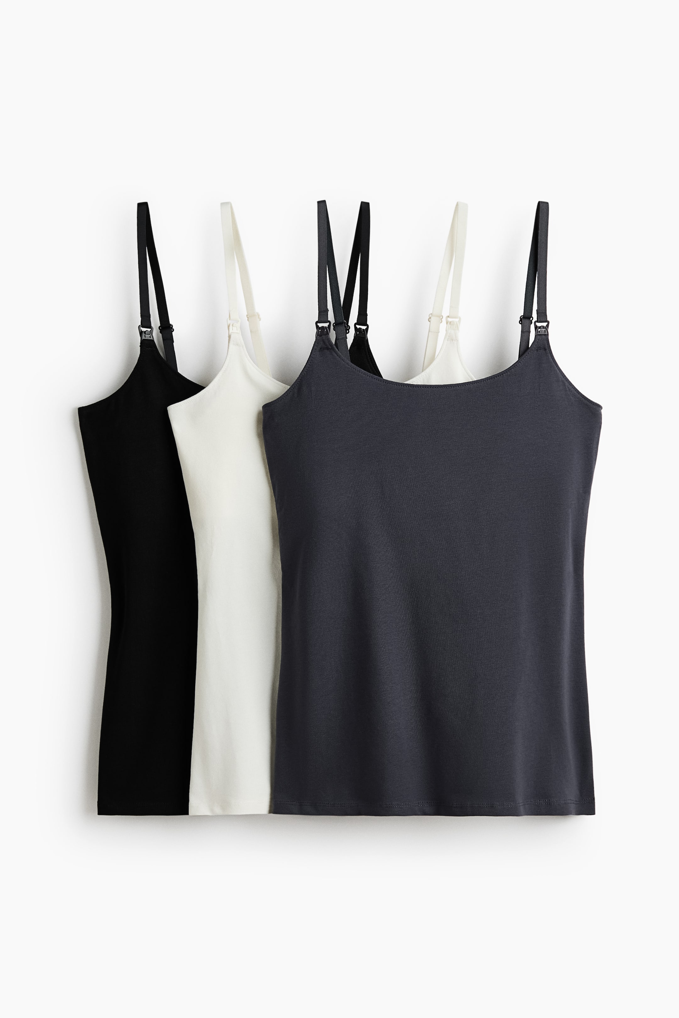 Voir une image plus grande: Trois camisoles d'allaitement sont présentées de face, en noir, blanc cassé et gris foncé. Elles sont conçues avec des bretelles étroites et ajustables dotées de clips d'allaitement et d'un ourlet simple.