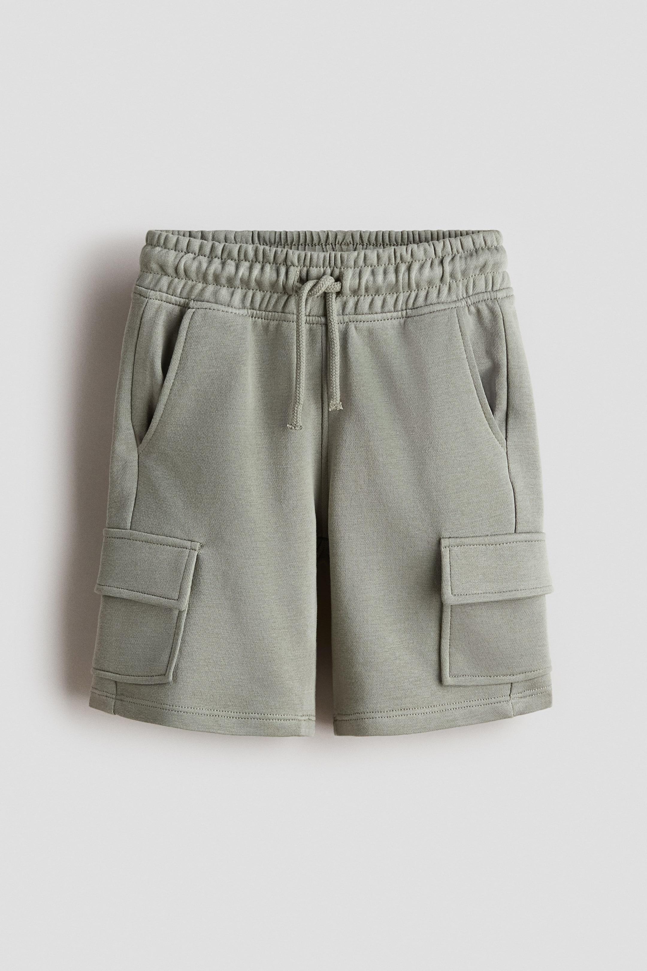 Visa större bild: Knälånga cargoshorts i lätt sweatshirtmaterial presenteras av FRONT, med elastisk dragsko i midjan, diagonala sidofickor och fickor med lock på benen.