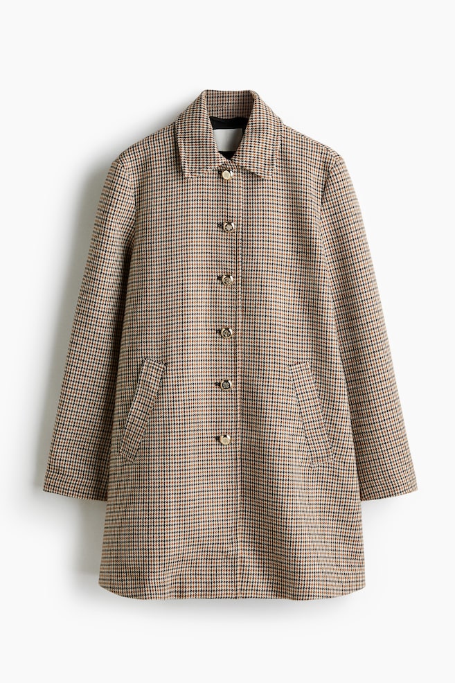A tan, black, and brown houndstooth coat is being presented from the front. It is featuring a pointed collar, five round gold-toned buttons down the center, and two patch pockets on the lower front. - 1