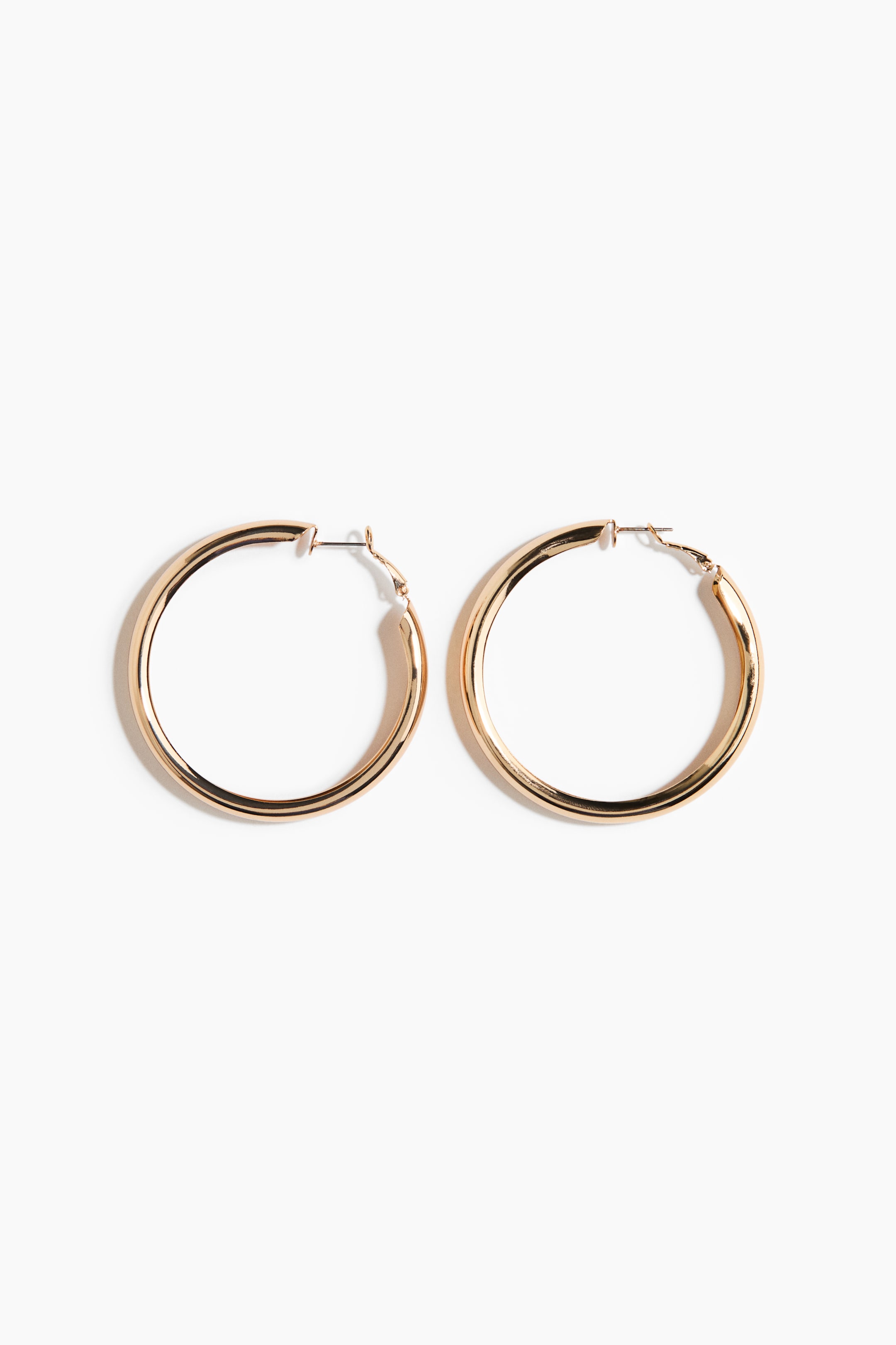 Преглед на по-голямо изображение: Обеци халки са с блестящо, златисто метално покритие и класическа кръгла форма. Всяка обеца е с лостово закопчаване в горната част.