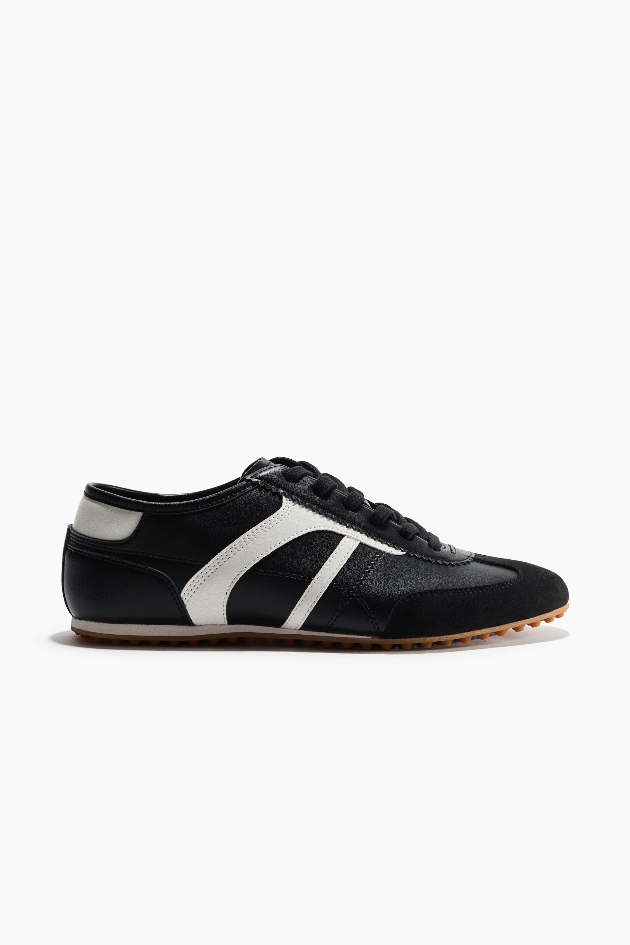 View larger image: The low-top sneaker features a black leather upper with white stripes on the side panel. It also includes a black suede-like toe cap, a black heel counter with a white accent, black laces, and a tan rubber sole.