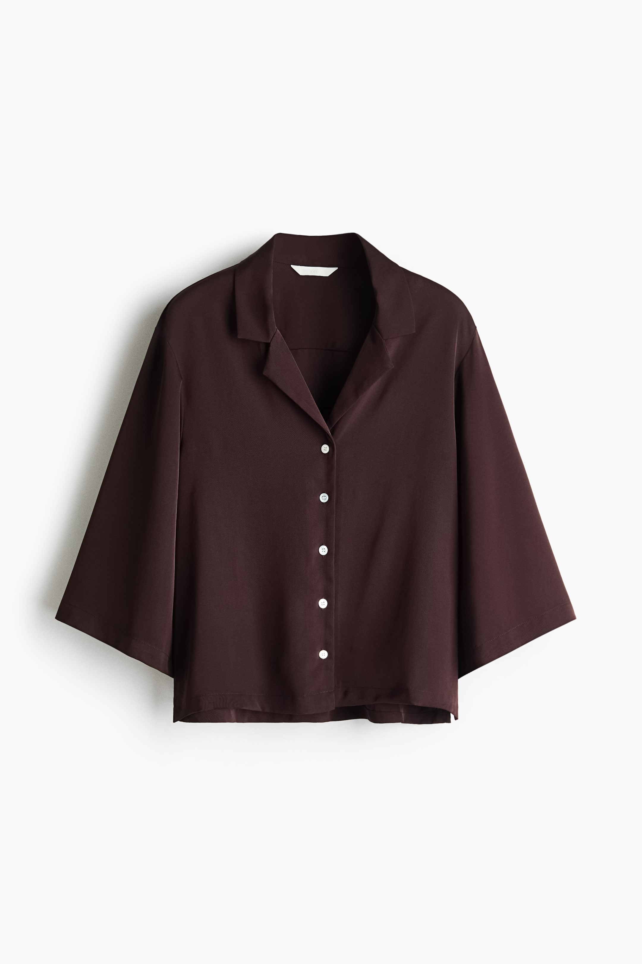 View larger image: A dark brown loose-fit shirt in twill showcases its front view, featuring a resort collar and five visible white buttons down the front. It is crafted with elbow-length sleeves, a straight-cut hem, and a slit at each side.