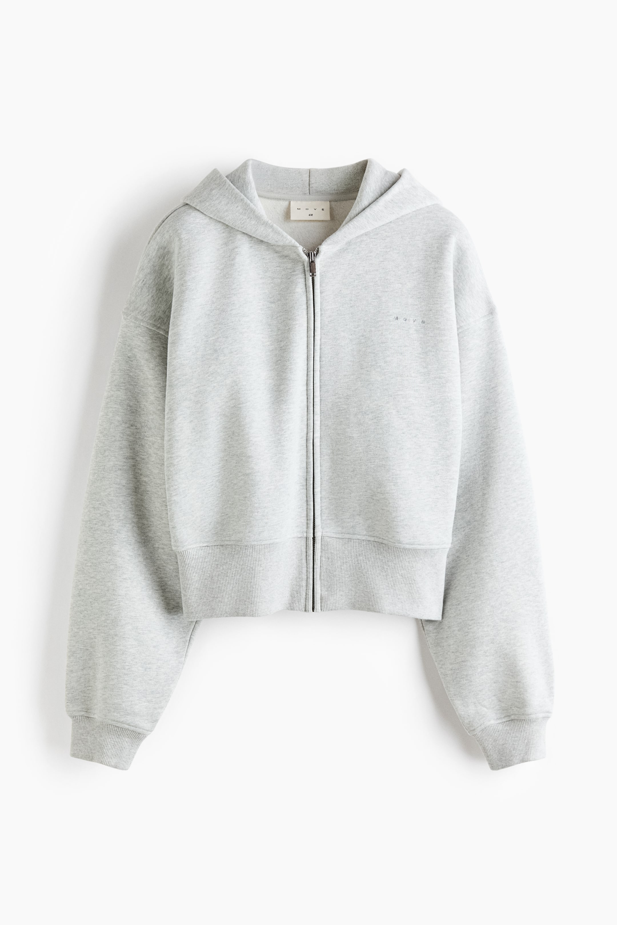 View larger image: A light grey zip-up cropped hoodie is shown facing the front, featuring a relaxed fit with dropped shoulders, a hood, and a front zip fastening. The hoodie is designed with a wide ribbed hem and ribbed cuffs.