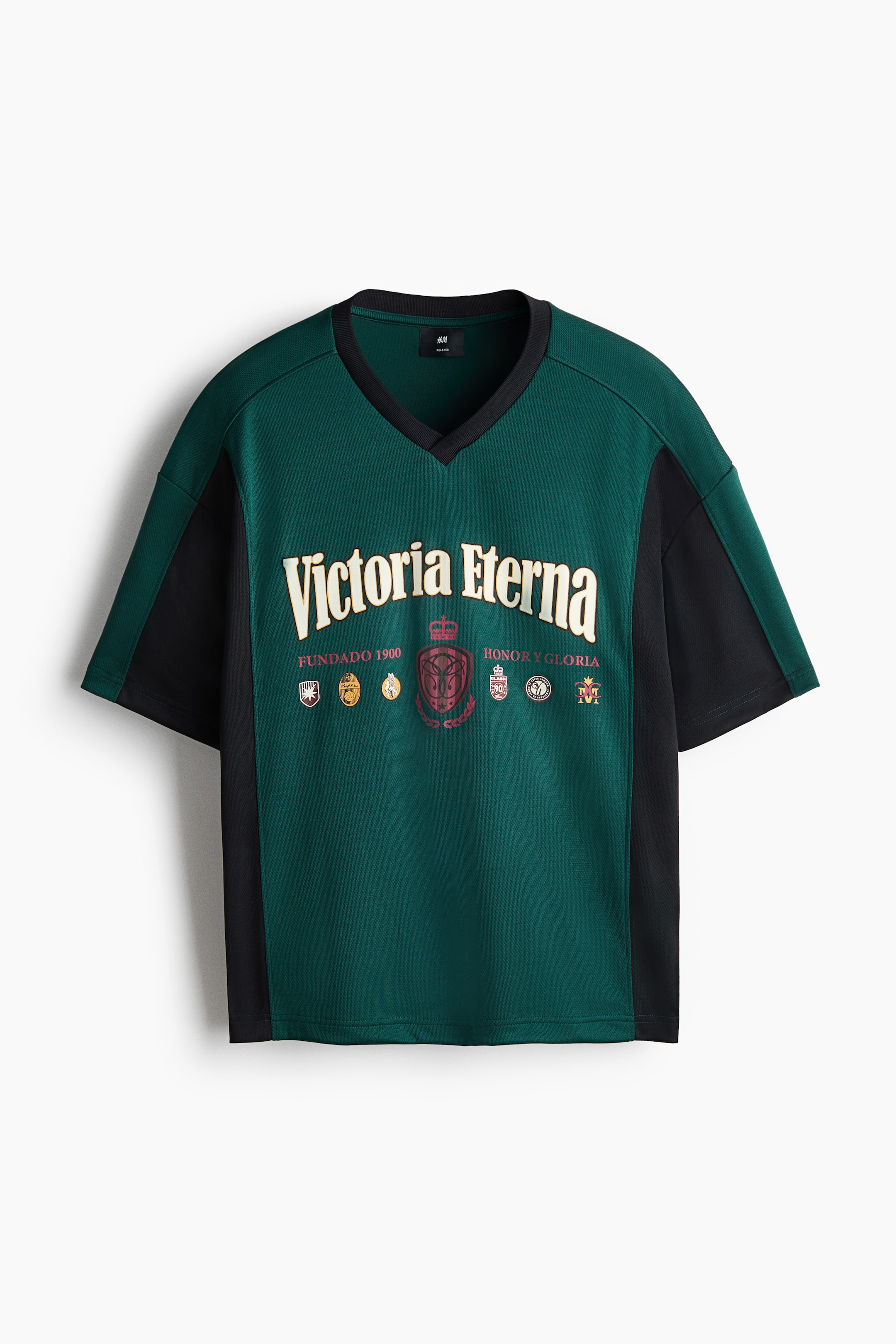 View larger image: The t-shirt showcases a dark green jersey body with black side panels and short sleeves. It is crafted with a black rib-trimmed V-neckline, adorned with a cream 'Victoria Eterna' print featuring crest motifs on the front, and a straight-cut hem, offering a relaxed fit.