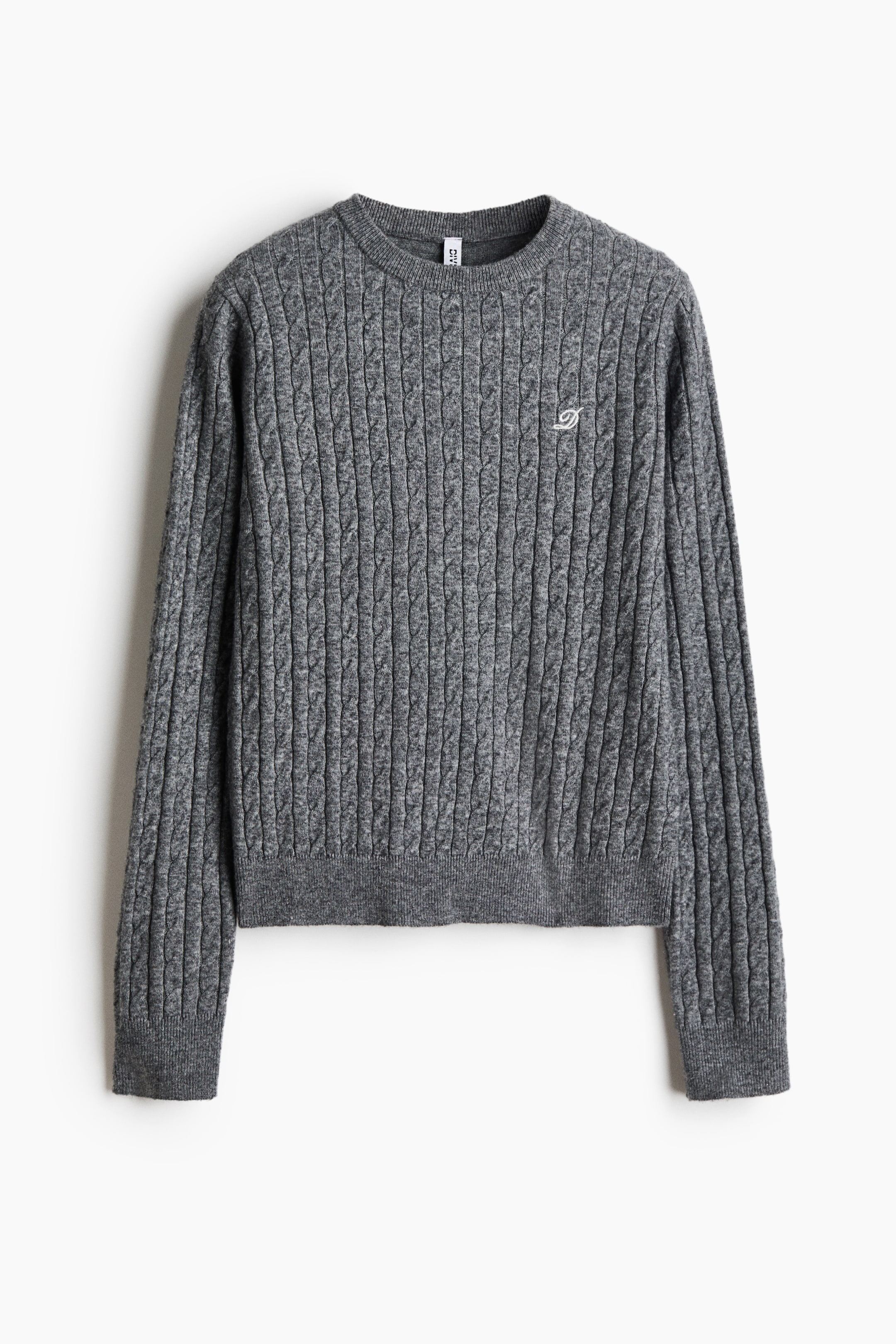 View larger image: A grey cable-knit sweater is shown from the front, featuring a ribbed crew neck, ribbed cuffs, and a ribbed hem. The sweater features a vertical cable-knit pattern throughout the body and sleeves, with a small white embroidered monogram on the left chest.